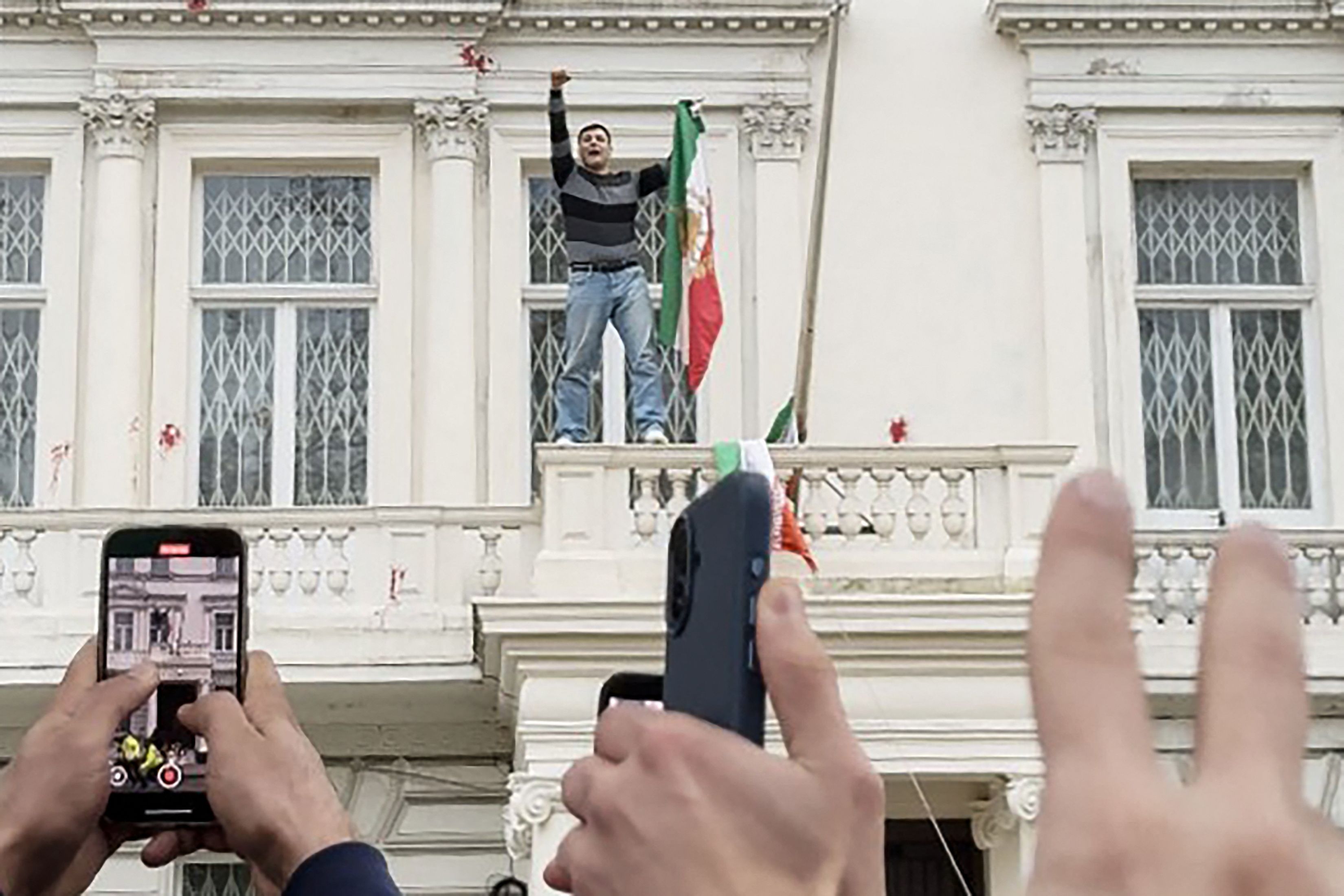 Ein Demonstrant auf dem Balkon der iranischen Botschaft im Zentrum Londons, er riss die aktuelle Flagge des Landes herunter