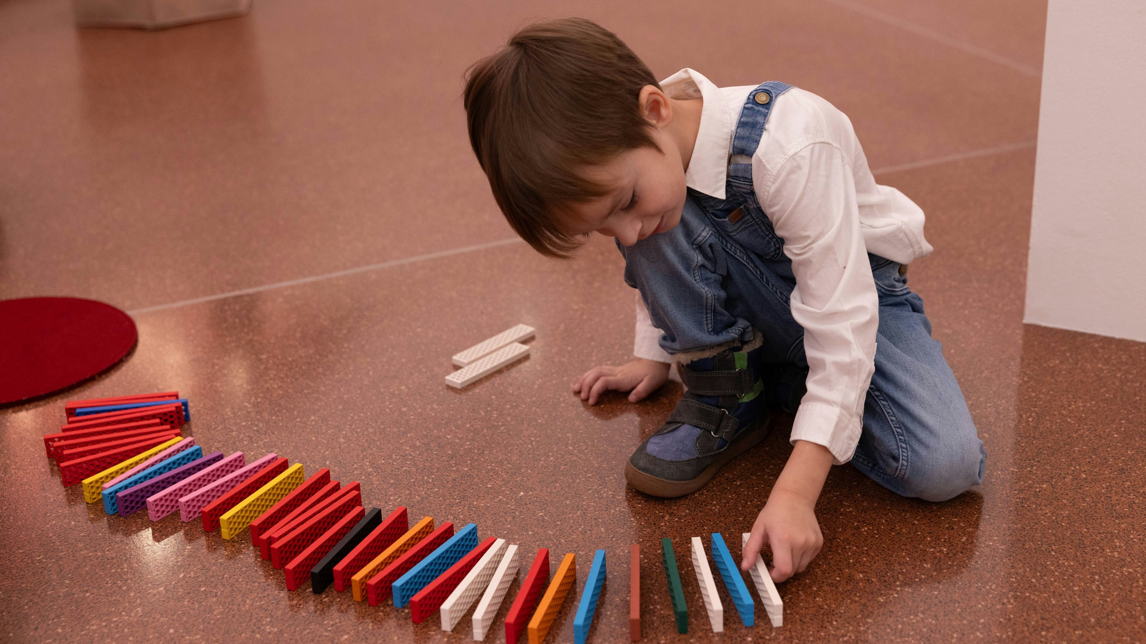 Kinder und ihre Familien bauen die längste Bioblo-Linie, die ein Museum je gesehen hat.
