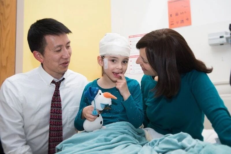 Mila mit ihrer Mutter und Doktor Timothy Yu