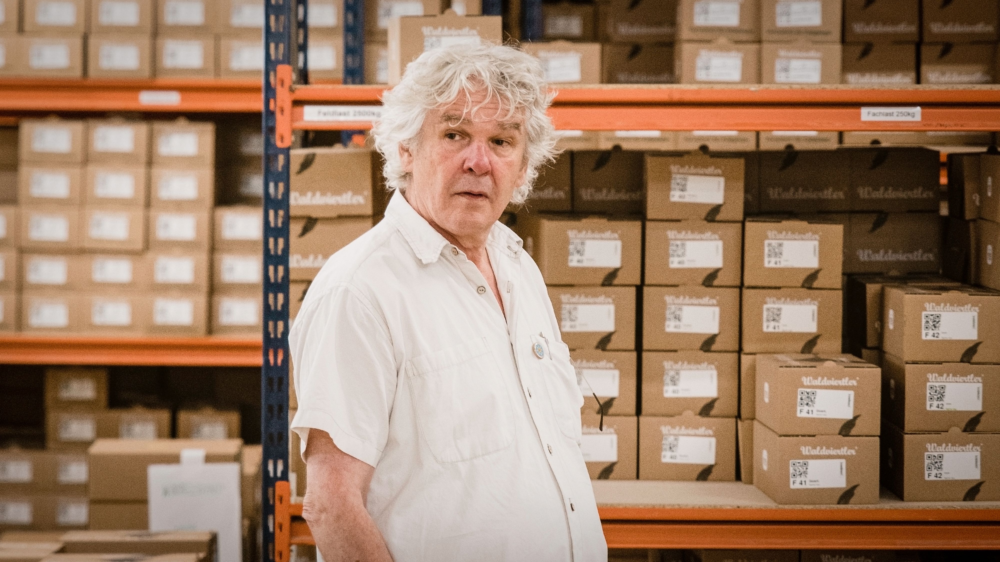 Heini Staudinger, der Gründer und Inhaber von GEA, dem Hersteller der Waldviertler Schuhe, vor einem Lagerregal in der GEA-Zentrale in Schrems.