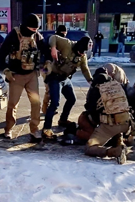 Der entscheidende Moment in Minneapolis, ein Beamter (in grüner Jacke) zieht seine Waffe