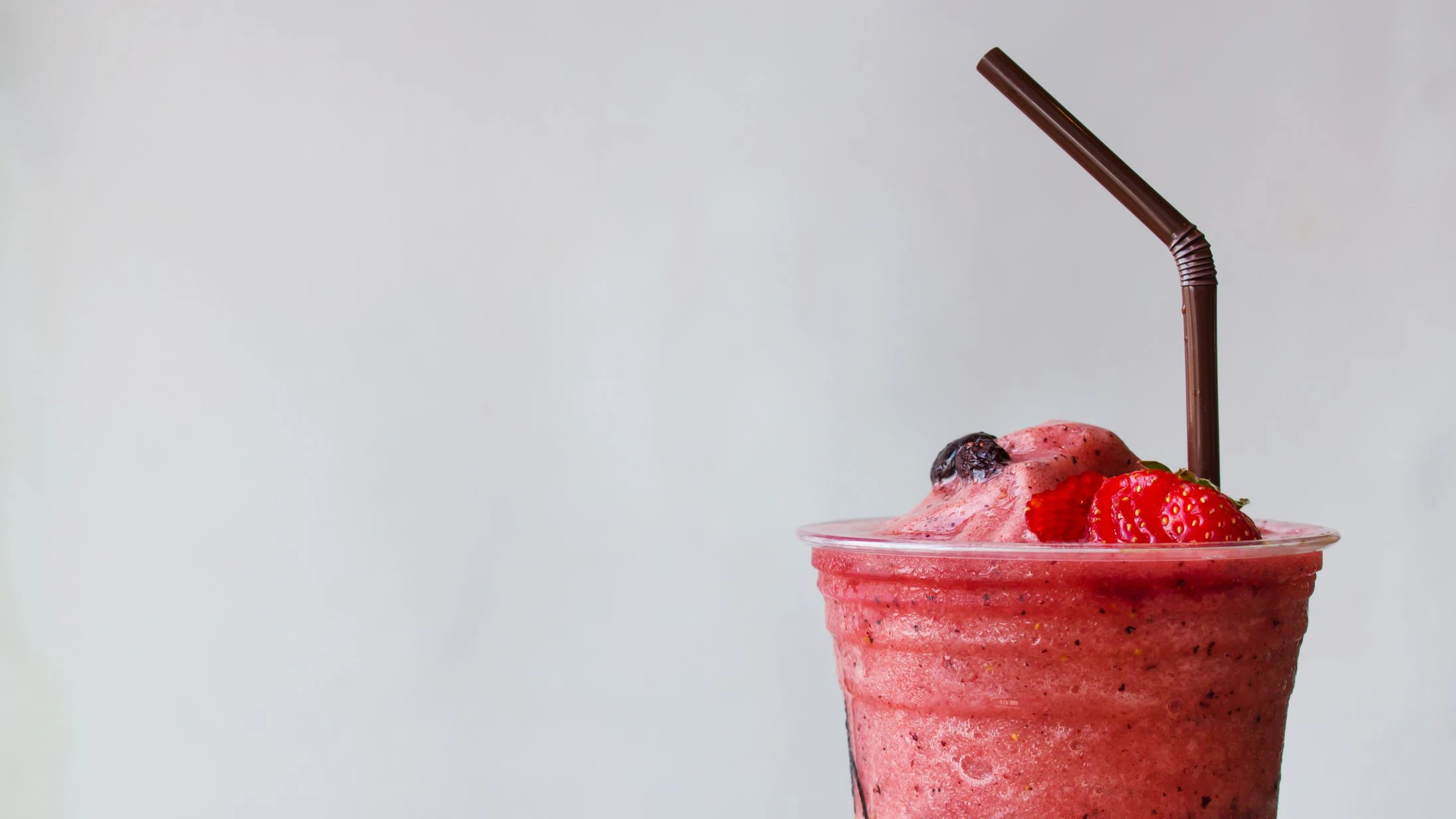 Closeup top of strawberry and blueberry smoothies in plastic cup. Refreshment healthy drink. Food and drink background. Copy space with white background.
