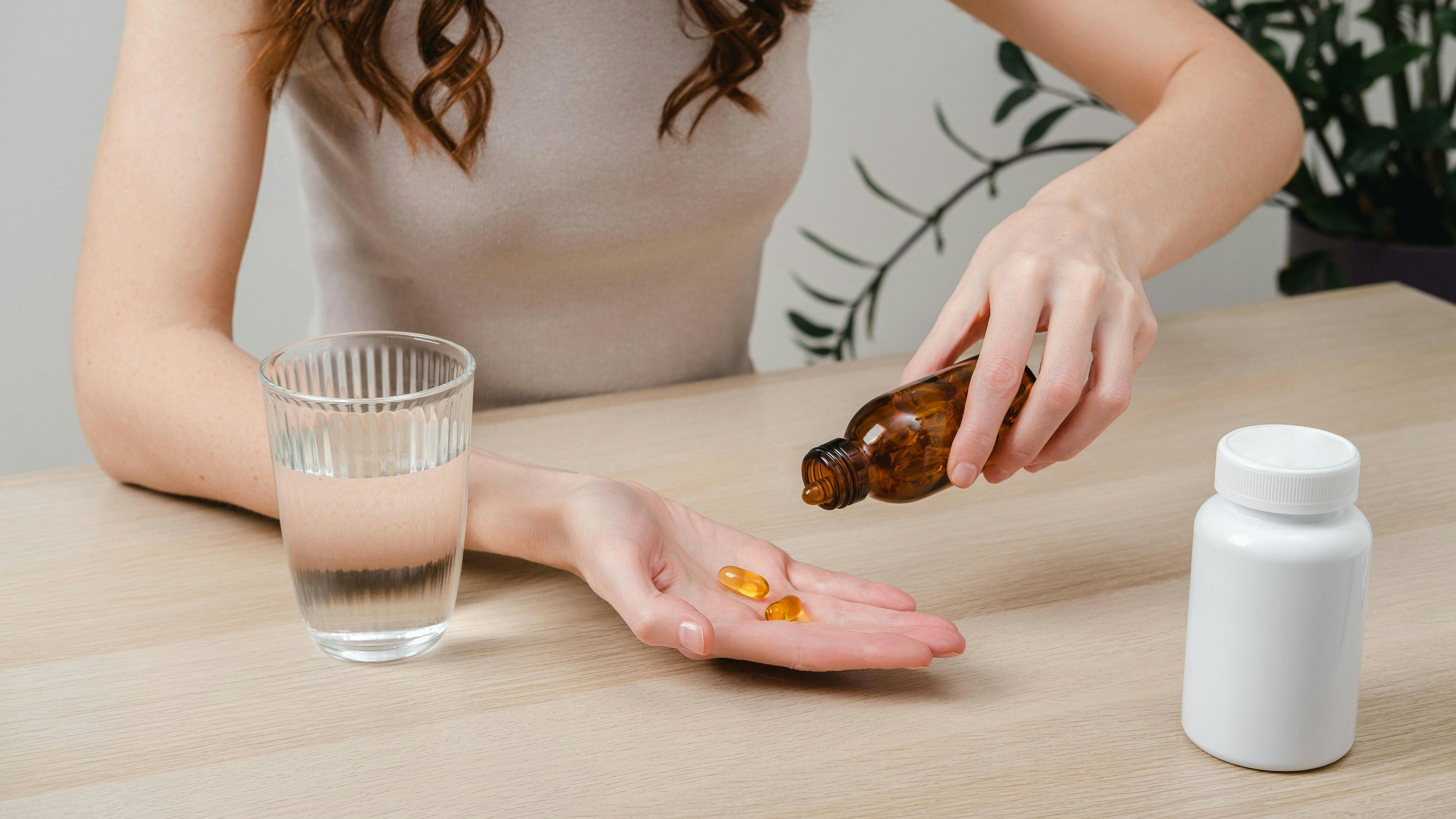 A woman holds omega-3 fish oil capsules. Healthy lifestyle, prevention and treatment of diseases. The woman takes and drinks dietary supplements and vitamins for skin, nails and hair. Intake of healthy fats. || Modellfreigabe vorhanden