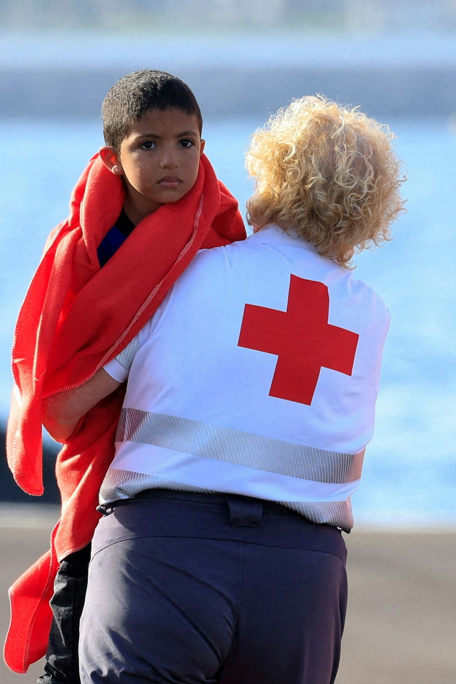 Eine Helferin kümmert sich um ein minderjähriges Kind, das mit dem Boot nach Spanien gekommen ist