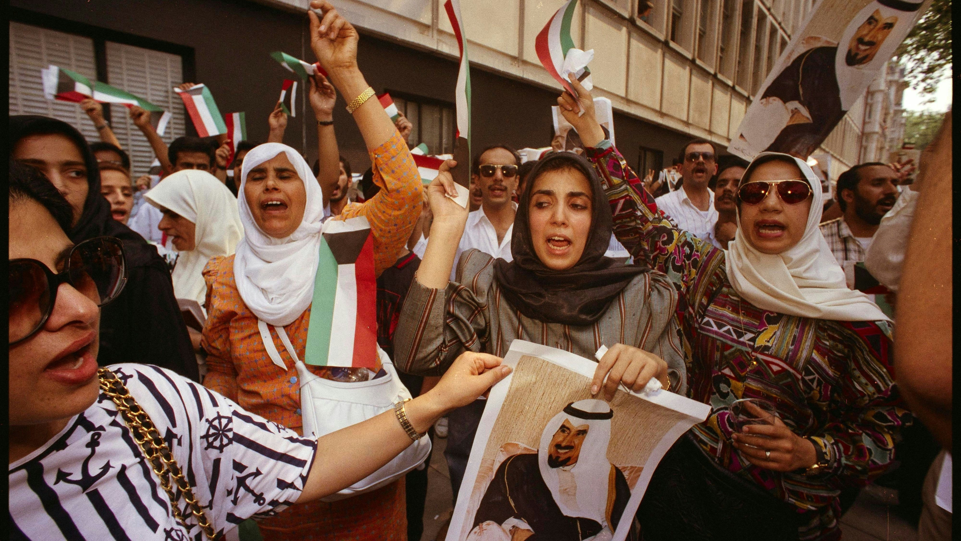 Kuwaitische Frauen mit den Flaggen ihres Landes und einem Plakat des kuwaitischen Herrschers Scheich Jaber al-Ahmed al-Sabah marschieren in Richtung der irakischen Botschaft in London