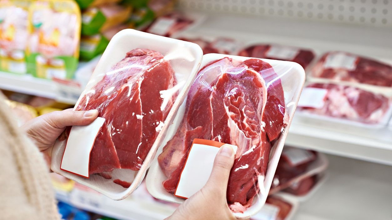 Buyer hands with beef meat packages at the grocery store