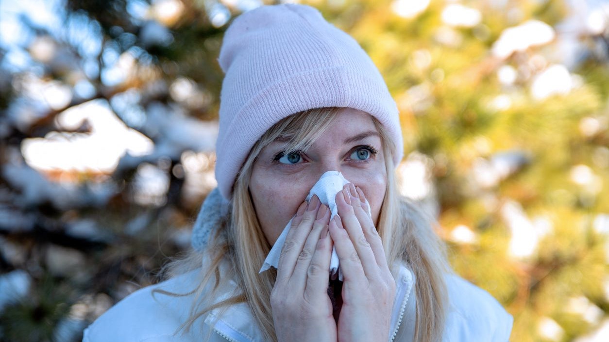 Female holding nose having Sinus ache. Woman with headache and health problem on winter day outdoor. Sharp strong sore. Flu cold or virus symptom. Copy space