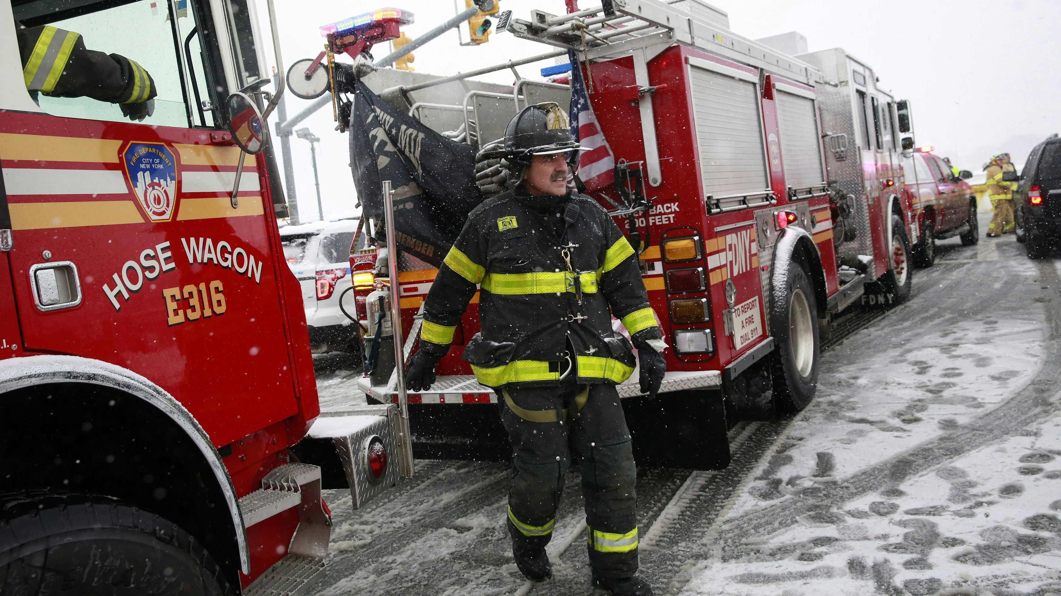 A fireman walks past firetrucks at LaGuardia Airport in New York March 5, 2015.  A Delta Air Lines jetliner with 125 passengers and five crew members aboard slid off the runway at New York's LaGuardia Airport on Thursday during a snowstorm, but there were no reported serious injuries, officials said.   REUTERS/Shannon Stapleton (UNITED STATES - Tags: DISASTER TRANSPORT ENVIRONMENT)