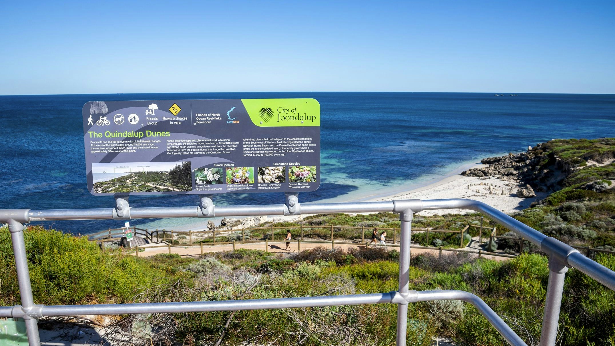 A picturesque viewpoint overlooking Quindalup Dunes and the clear waters of the ocean, captured under a sunny sky in Joondalup, showcasing the beauty of Western Australia's coastal landscape