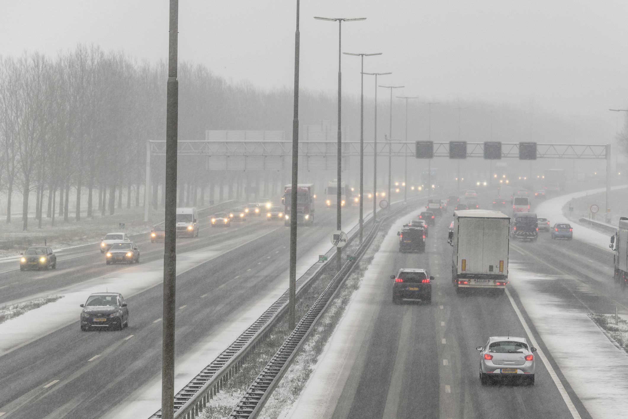 Traffic driving on a multiple lane highway during a snow blizzard in winter  near Zwolle in Overijssel, The Netherlands.