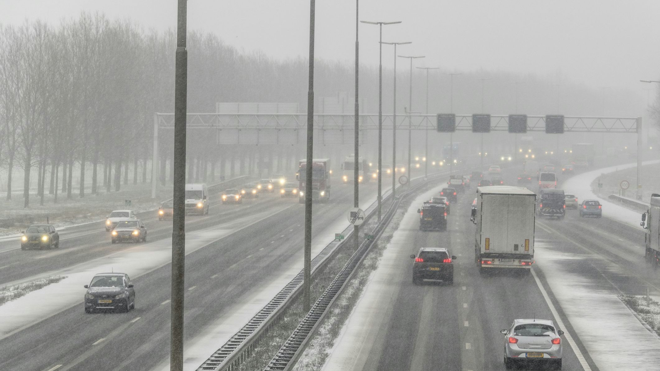Traffic driving on a multiple lane highway during a snow blizzard in winter  near Zwolle in Overijssel, The Netherlands.