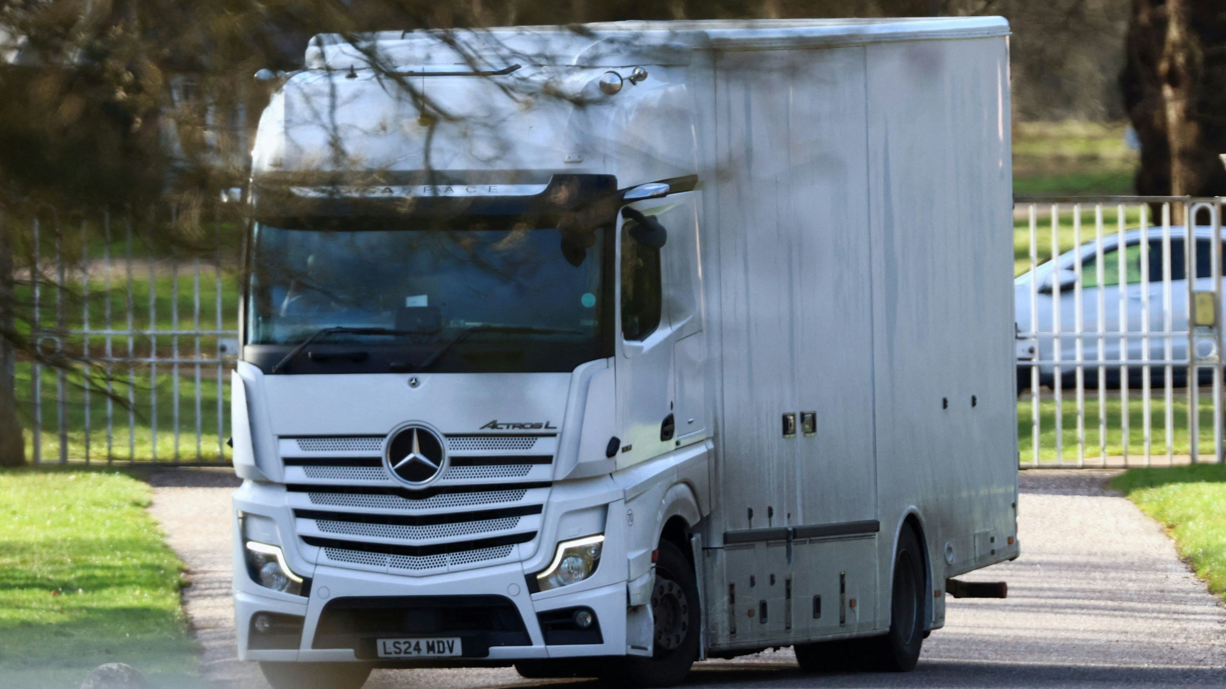 Auch ein Umzugslaster fährt von einem Eingang zur Royal Lodge weg.
