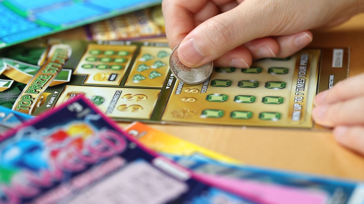 Coquitlam BC Canada - June 15, 2014 : Woman scratching lottery ticket called Monopoly. It's published by BC Lottery Corporation has provided government sanctioned lottery games. 