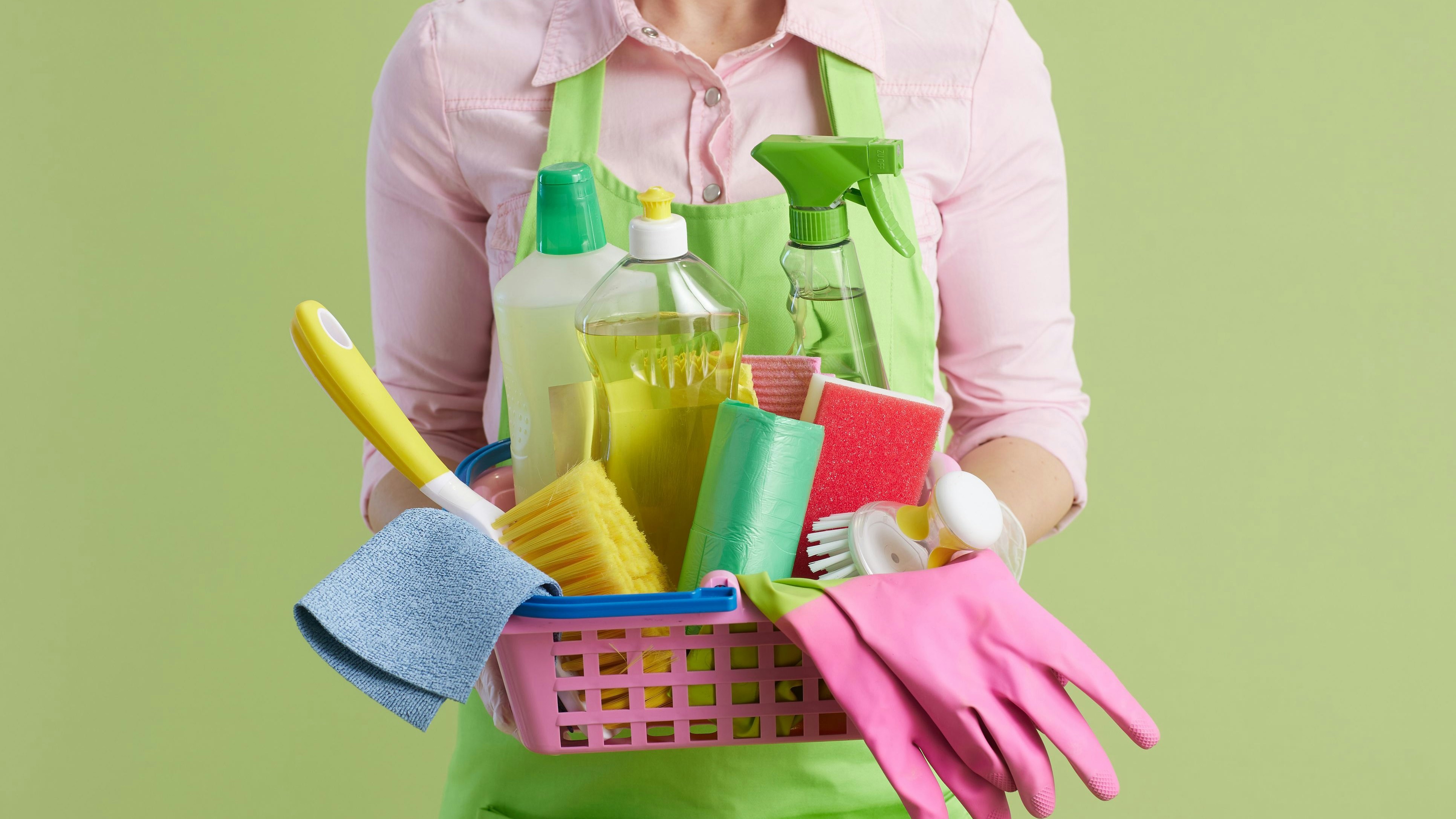 Frau trägt Putzmittel-Korb...