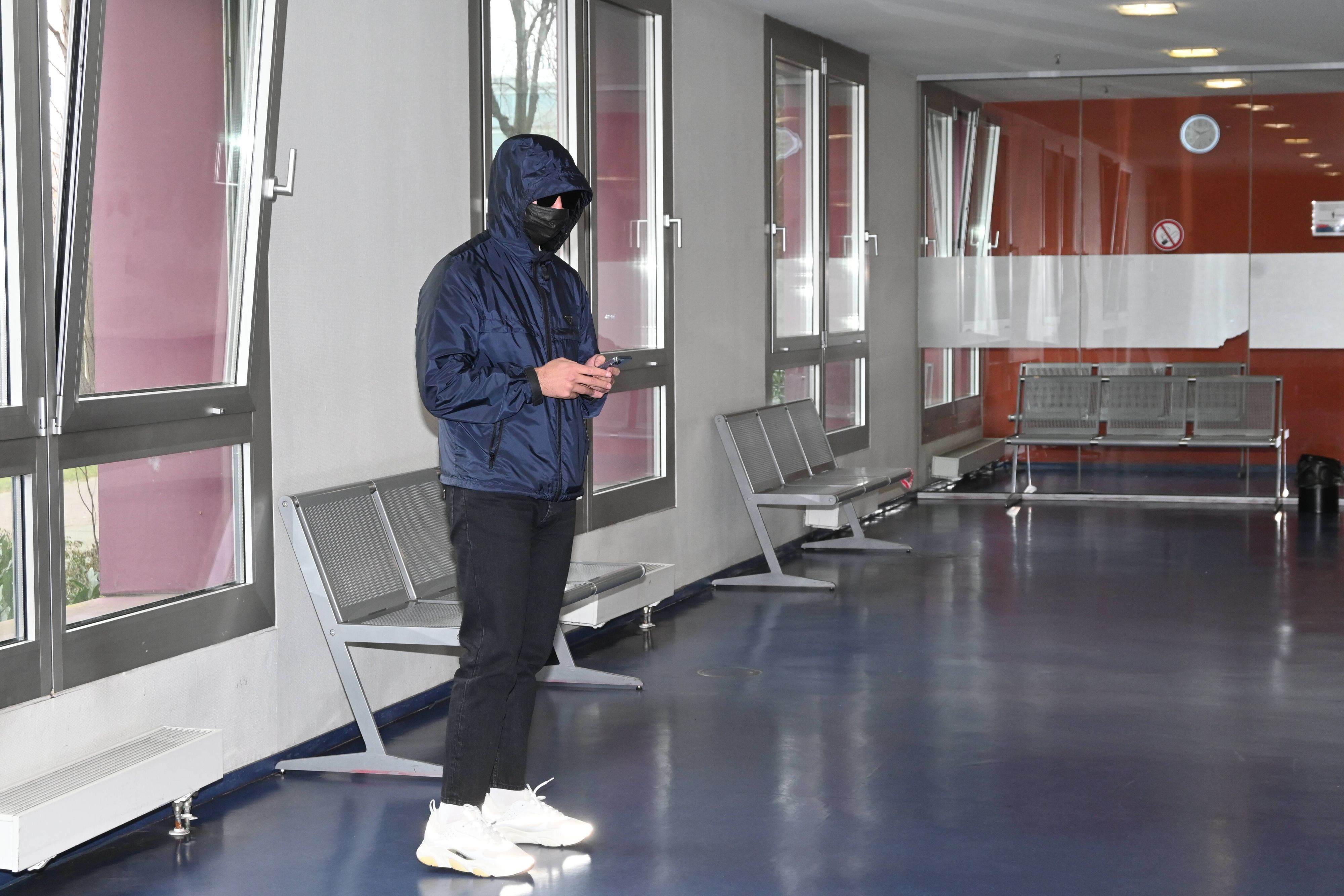 Rapper Kalim versteckt sich hinter Sonnenbrille, Maske und Kapuze vor Gericht.