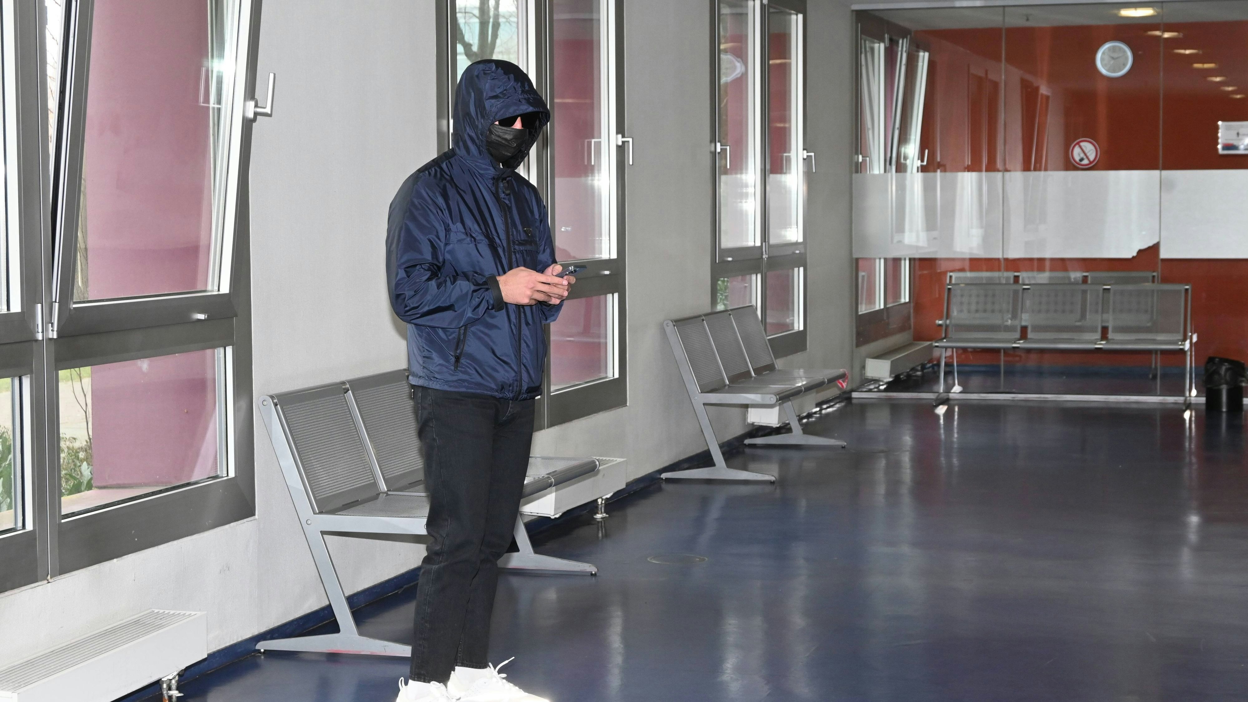 Rapper Kalim versteckt sich hinter Sonnenbrille, Maske und Kapuze vor Gericht.