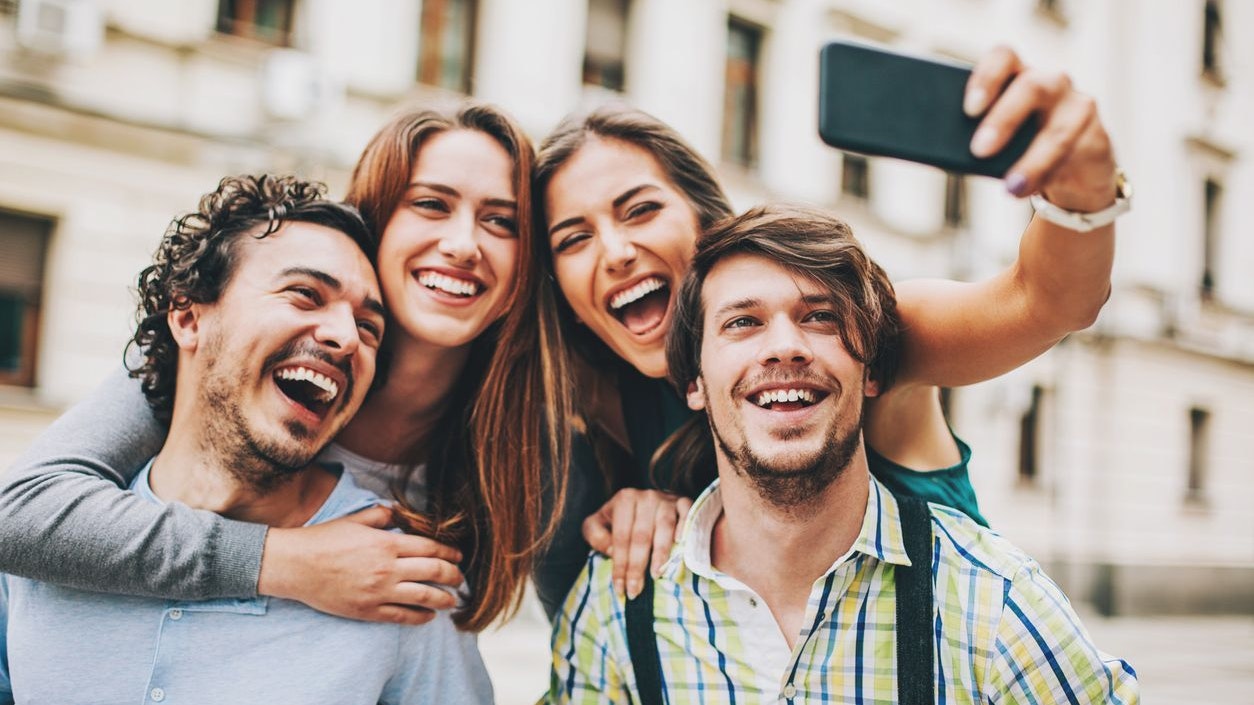 Two couples outdoors in the city in a funny pose for selfie