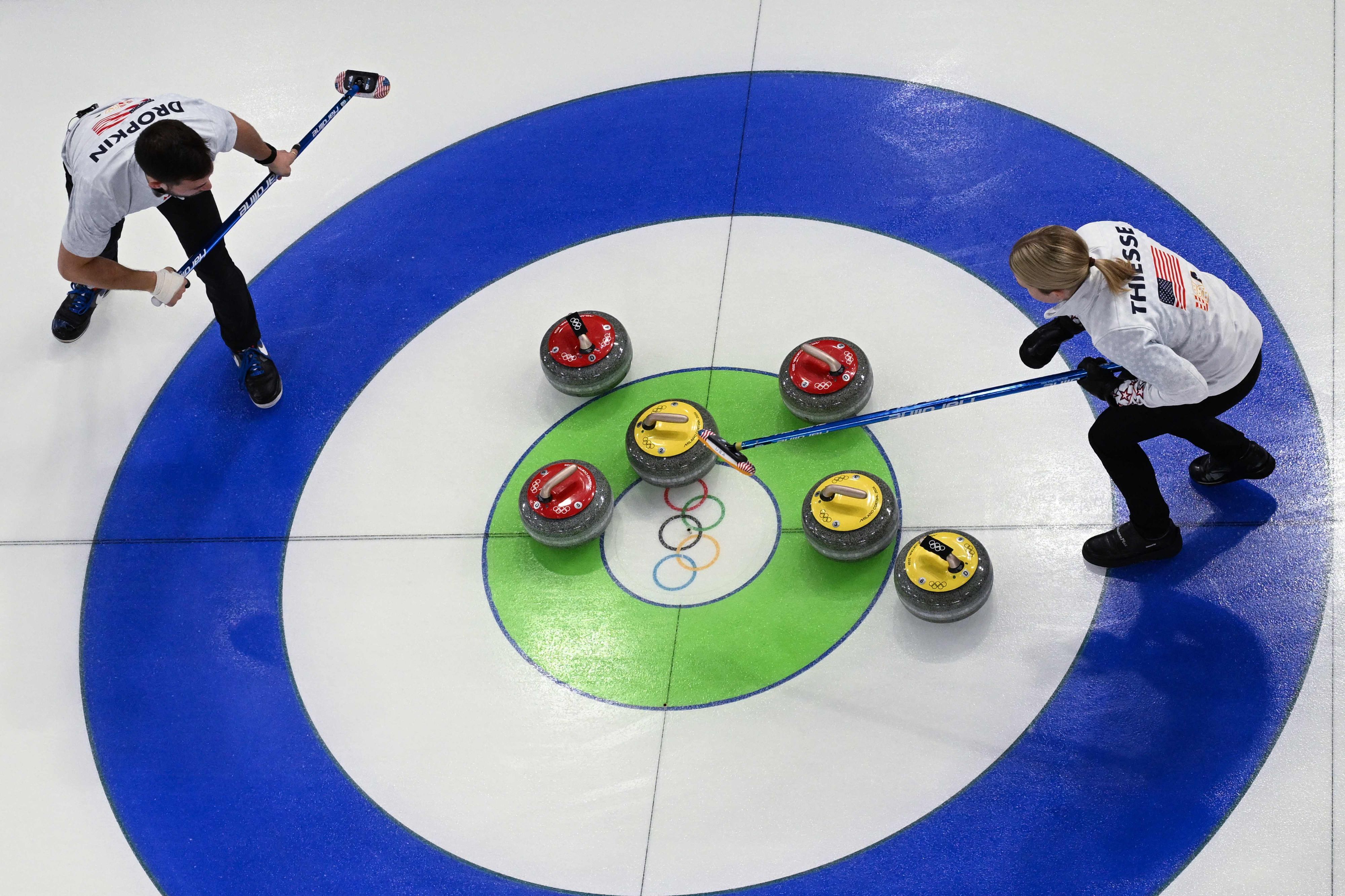 Die US-Amerikaner Cory Thiesse und Korey Dropkin besprechen, wohin der nächste Stein gehen soll. Das kreisrunde Ziel wird "Haus" genannt