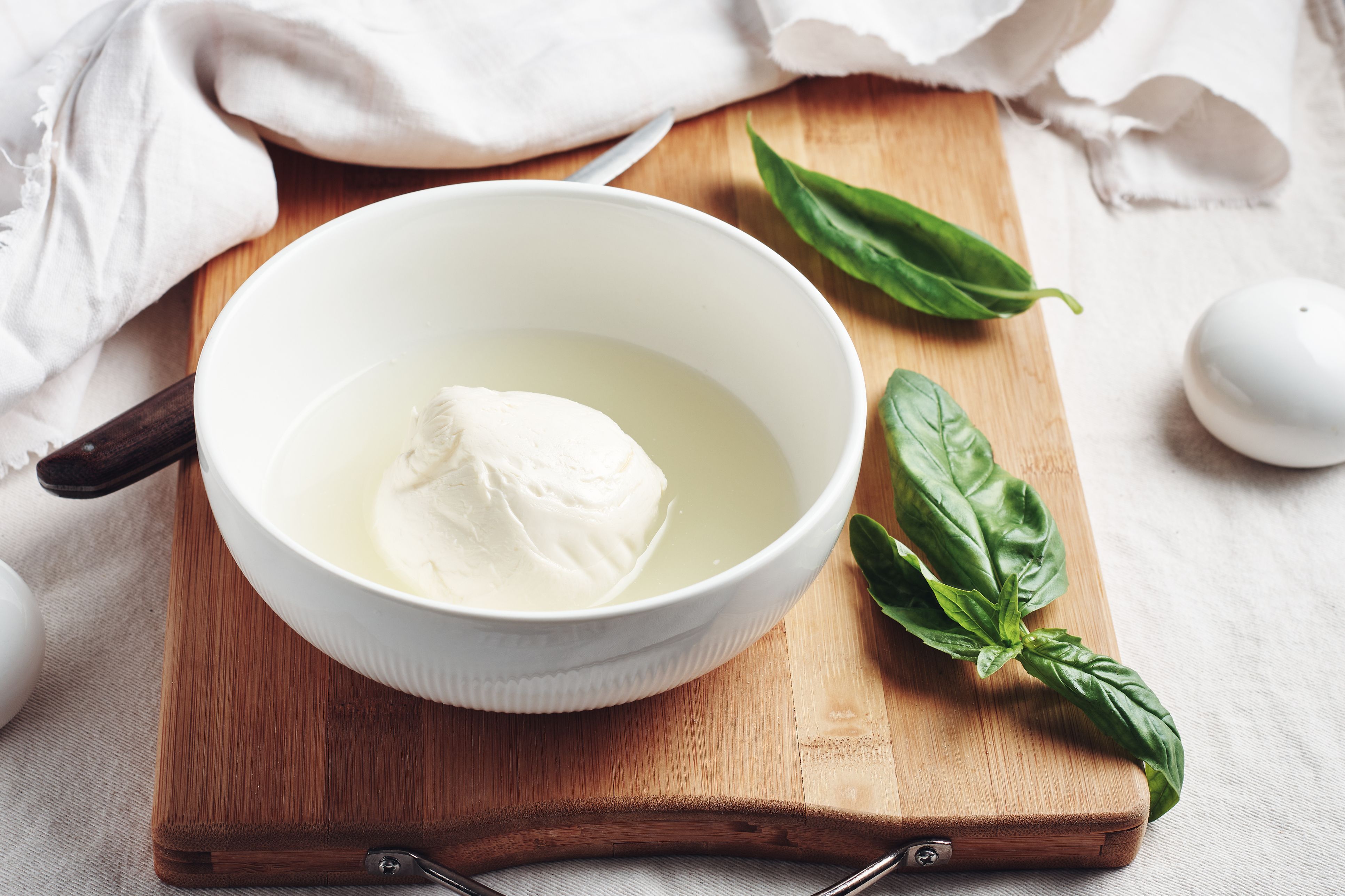 Wer einen angebrochenen Mozzarella länger frisch halten möchte, kann ihn wieder in etwas von der Lake einlegen.