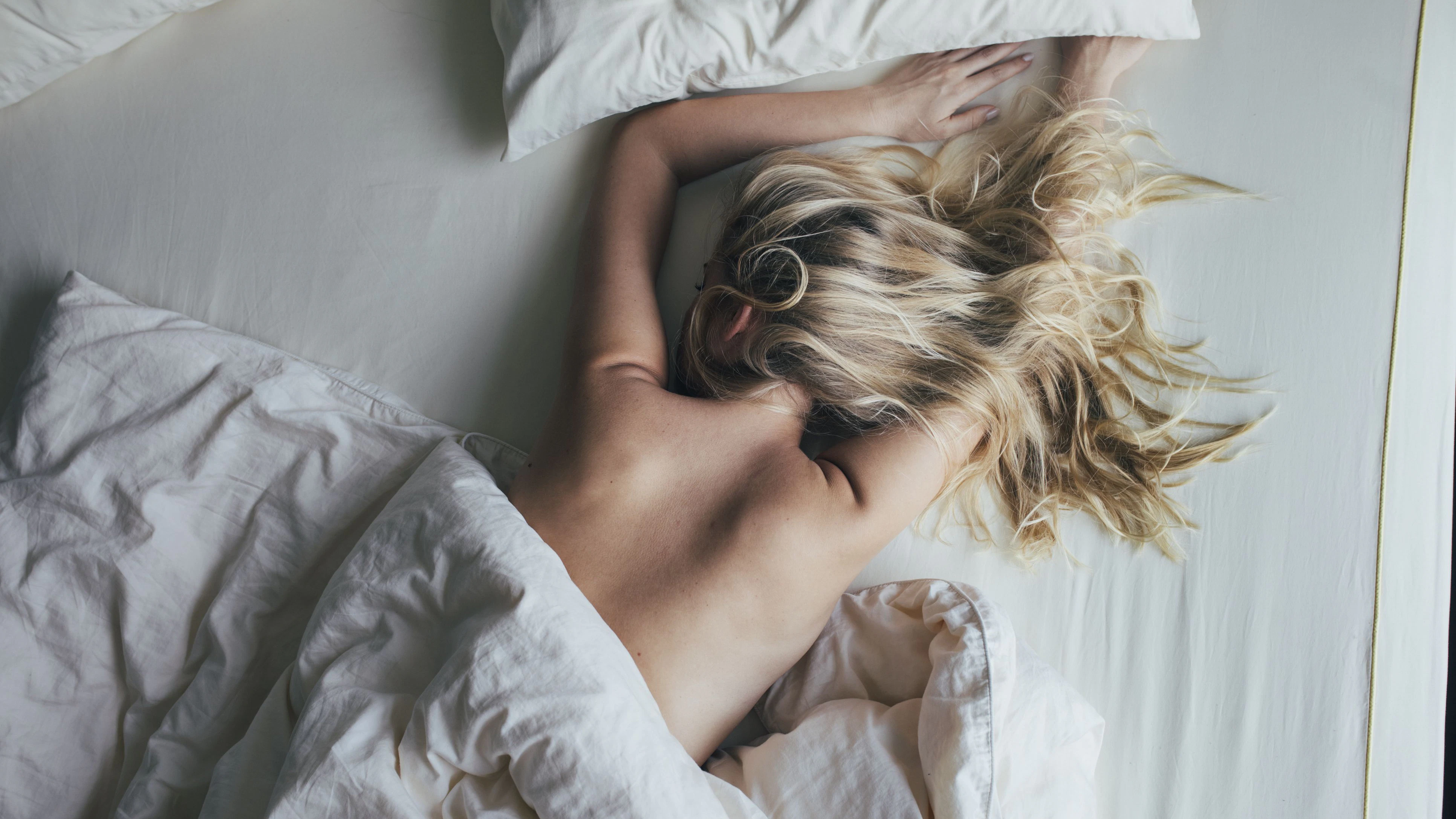Blonde Frau schläft nackt im Bett...