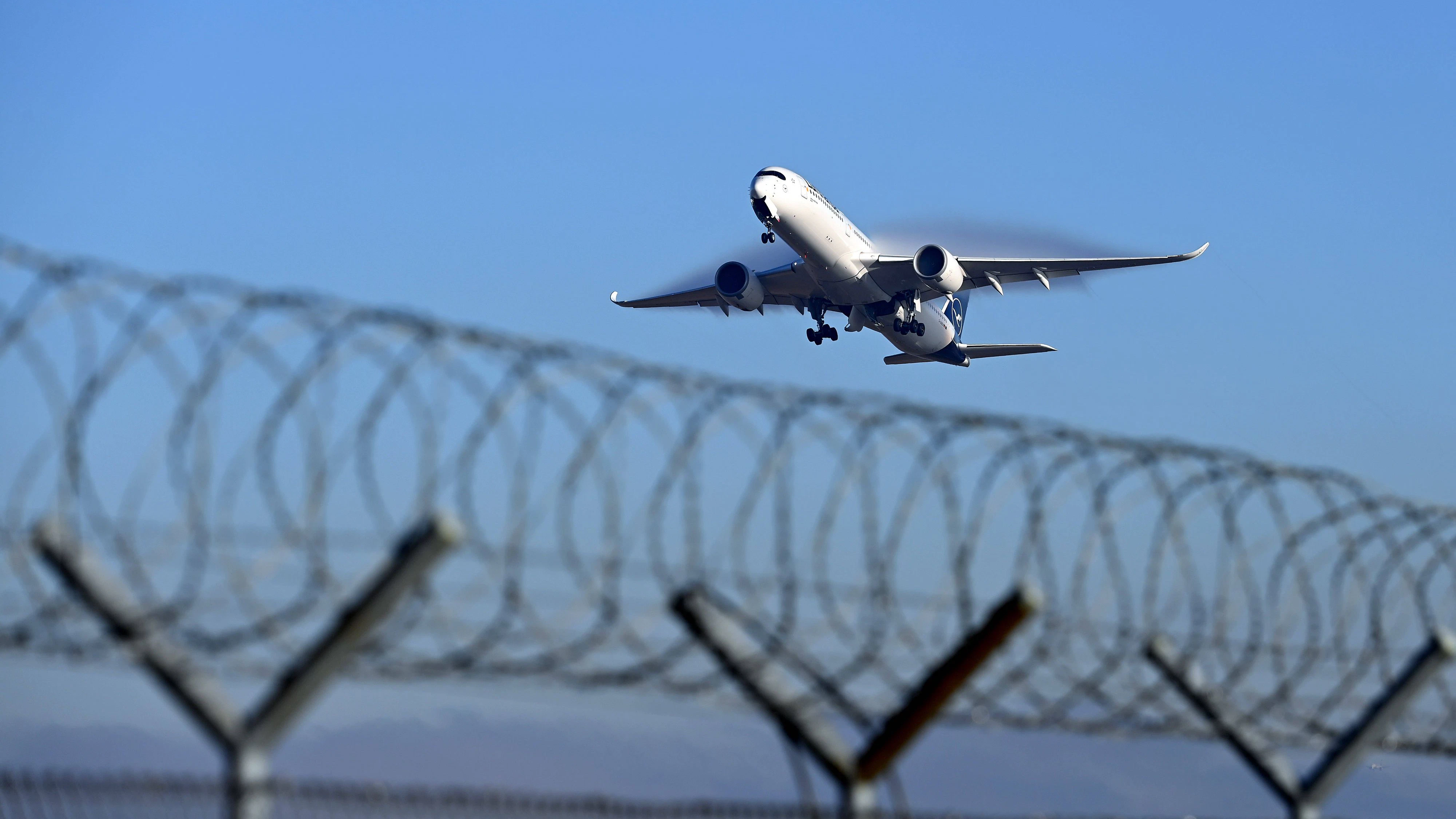 Symbolfoto Abschiebung abgewiesener Asylanten,Fluechtlinge,Migranten.Maschine hebt ab hinter S-Draht,Stacheldraht Zaun,Stacheldrahtzaun, *** Symbol photo deportation of rejected asylum seekers,refugees,migrants machine takes off behind S wire,barbed wire fence,barbed wire fence,