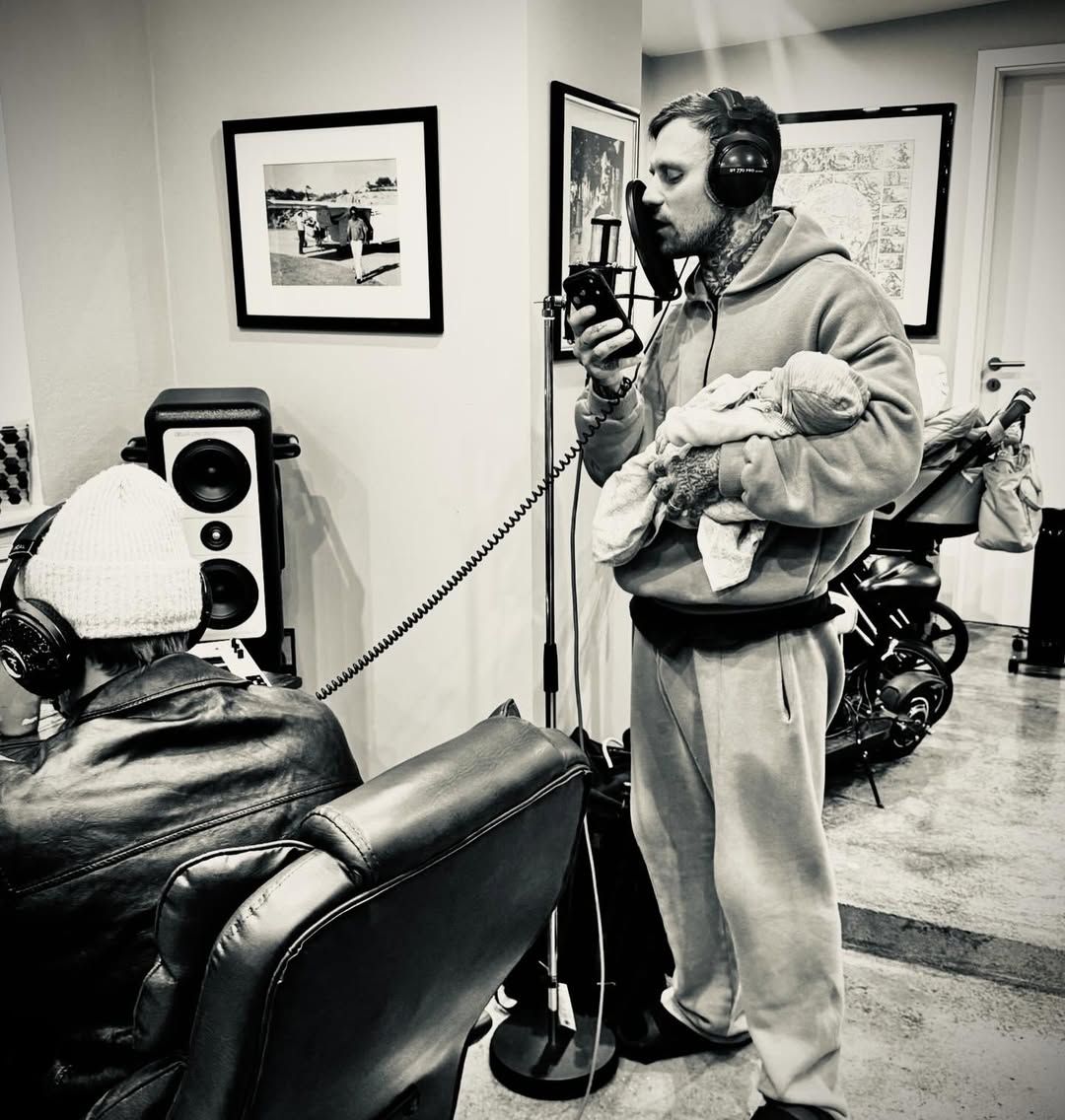 Kontra K hält sein Neugeborenes während einer Aufnahme im Arm.