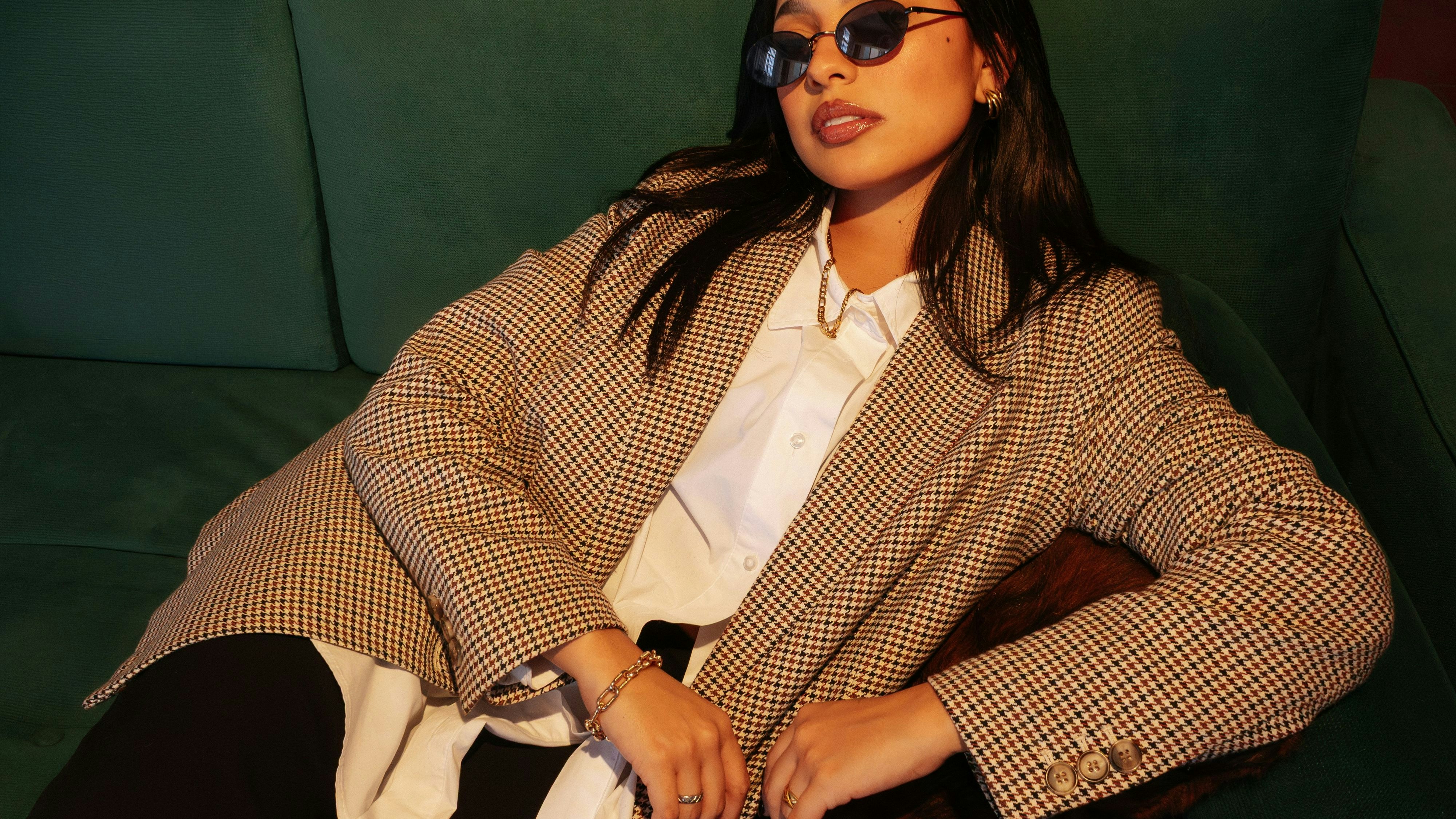 Blazer mit Geschichte – vielleicht einst im Kleiderschrank der Großmutter –, kombiniert mit schlichter Bluse und feinem Goldschmuck. Jung interpretiert, selbstverständlich getragen, ein stilles Spiel aus Erbe und Gegenwart.