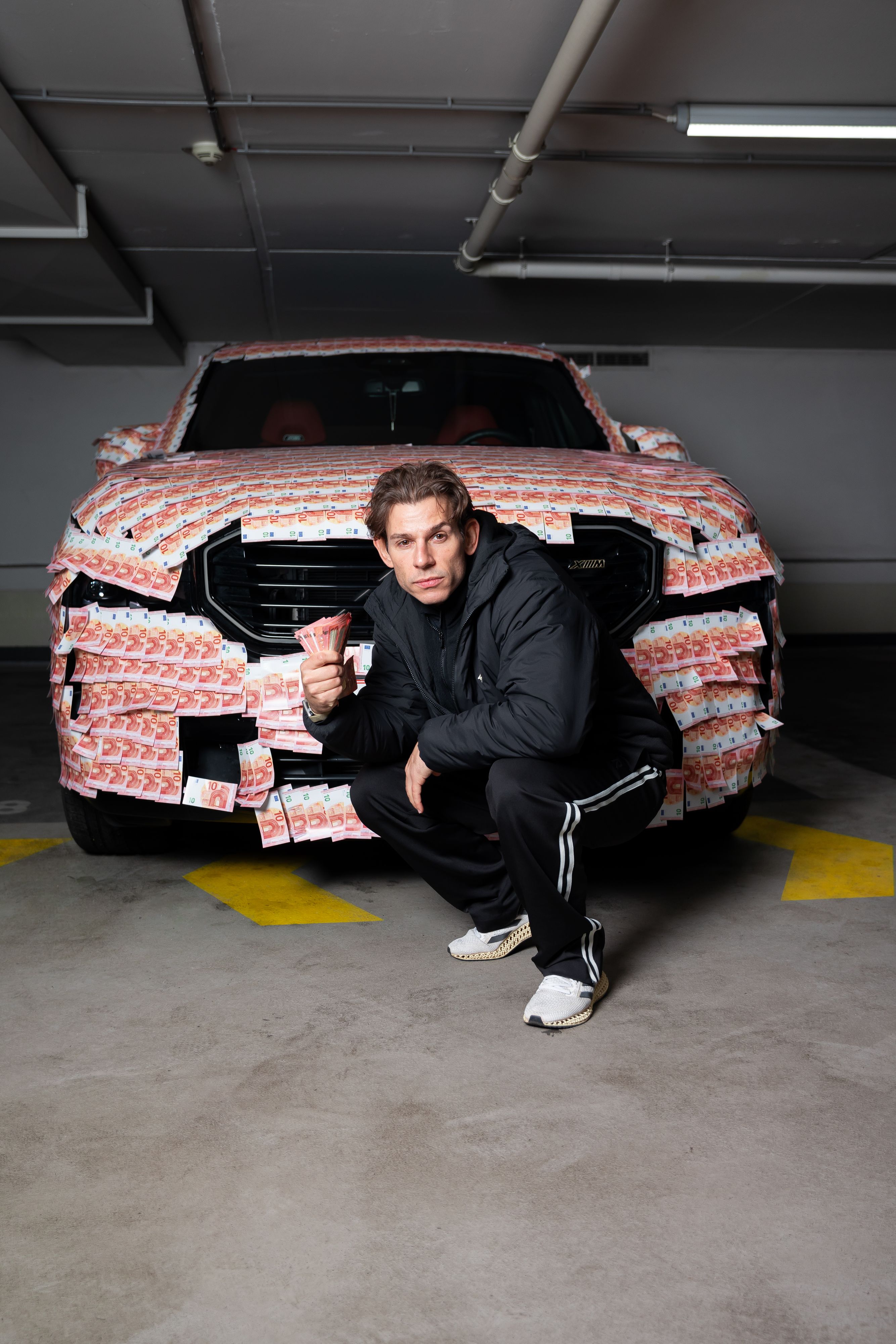 Weißenböck mit dem Auto, das mit Fake-Euro-Scheinen beklebt ist.