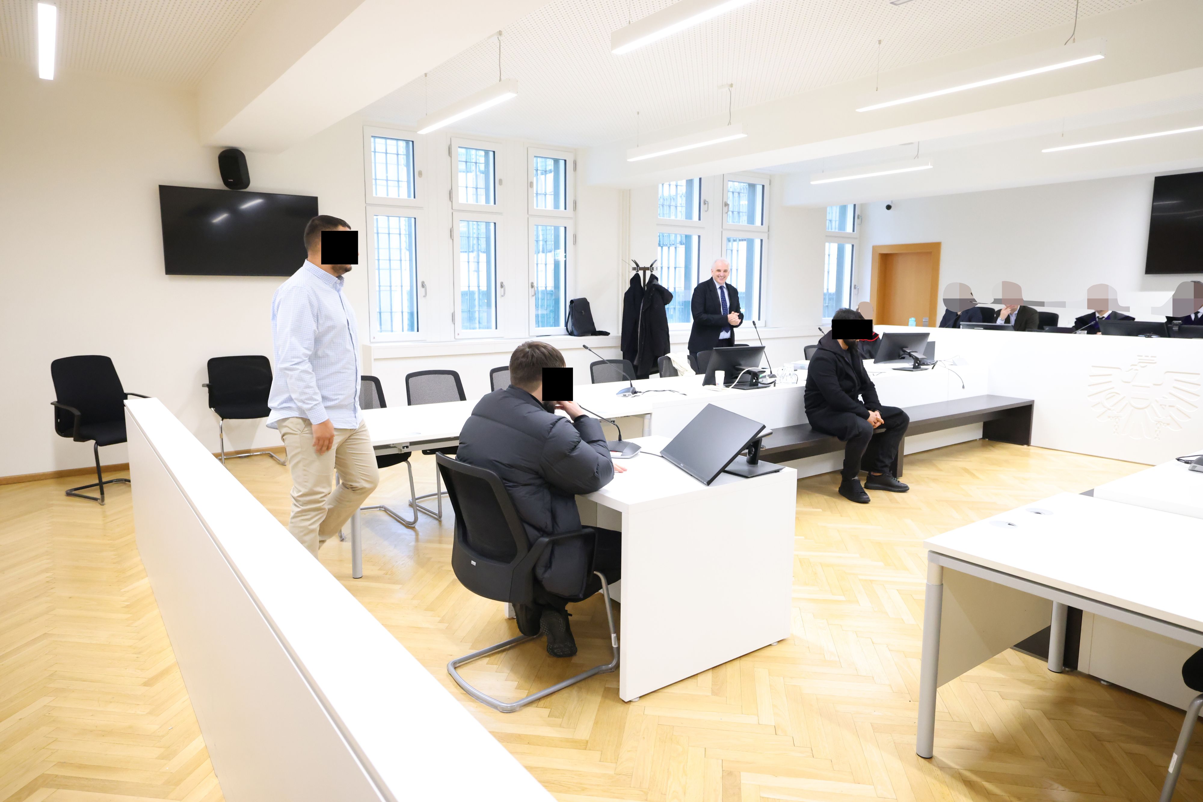 Die drei Verdächtigen vor Gericht; im Hintergrund Anwalt Michael Dohr.