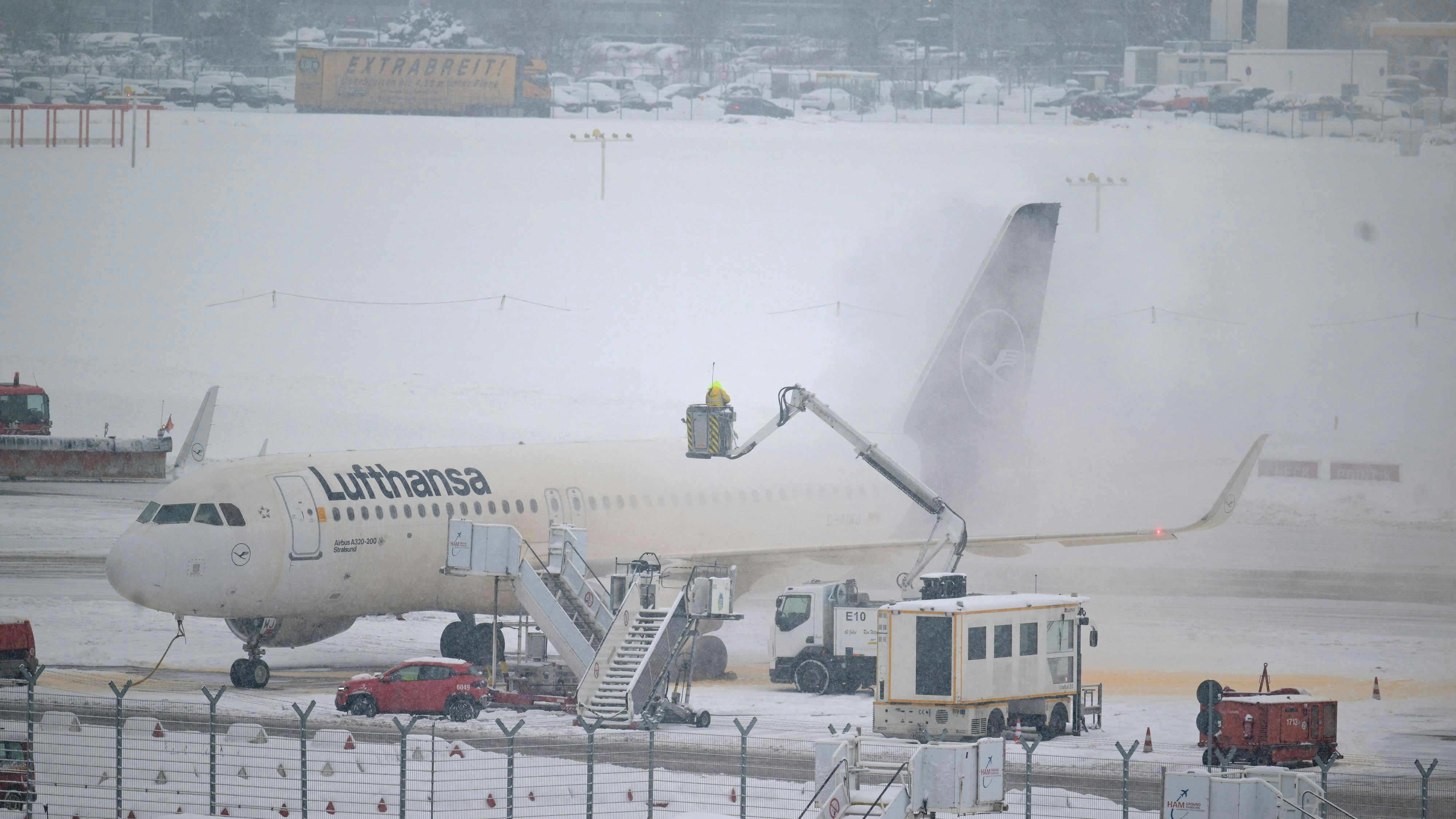 A Hamburg airport personnel works by a Luthansa plane, as Germany is bracing for adverse weather conditions this week, with forecasts predicting snow, storms, and freezing temperatures across large parts of the country, in Hamburg, Germany, January 8, 2026. REUTERS/Fabian Bimmer