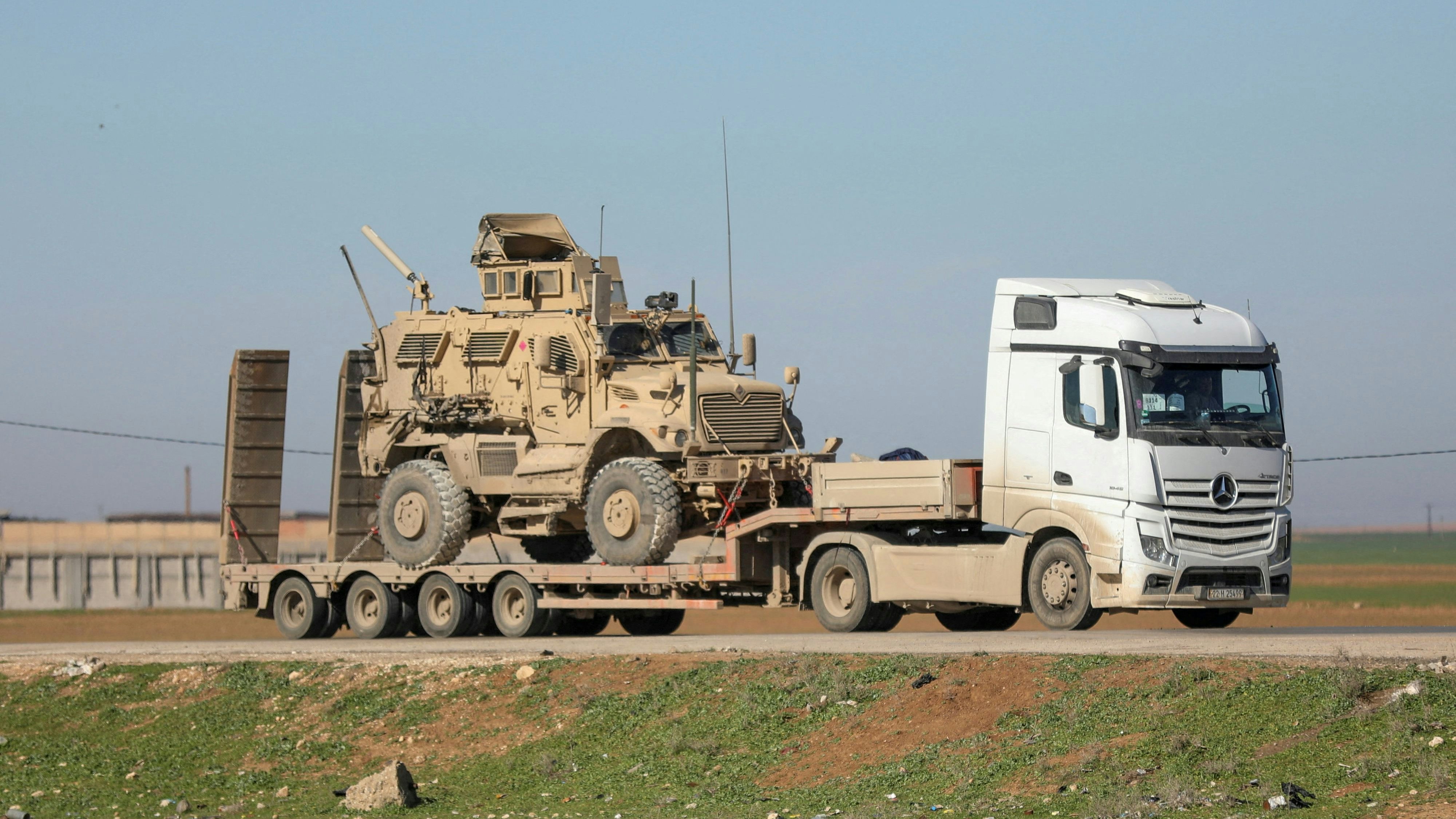 A trailer carries an armoured U.S. military vehicle as U.S. troops move towards the Iraqi Kurdistan region, withdrawing from Qasrak military base in northeastern Syria, in Qamishli, Syria, February 23, 2026. REUTERS/Orhan Qereman     TPX IMAGES OF THE DAY     
