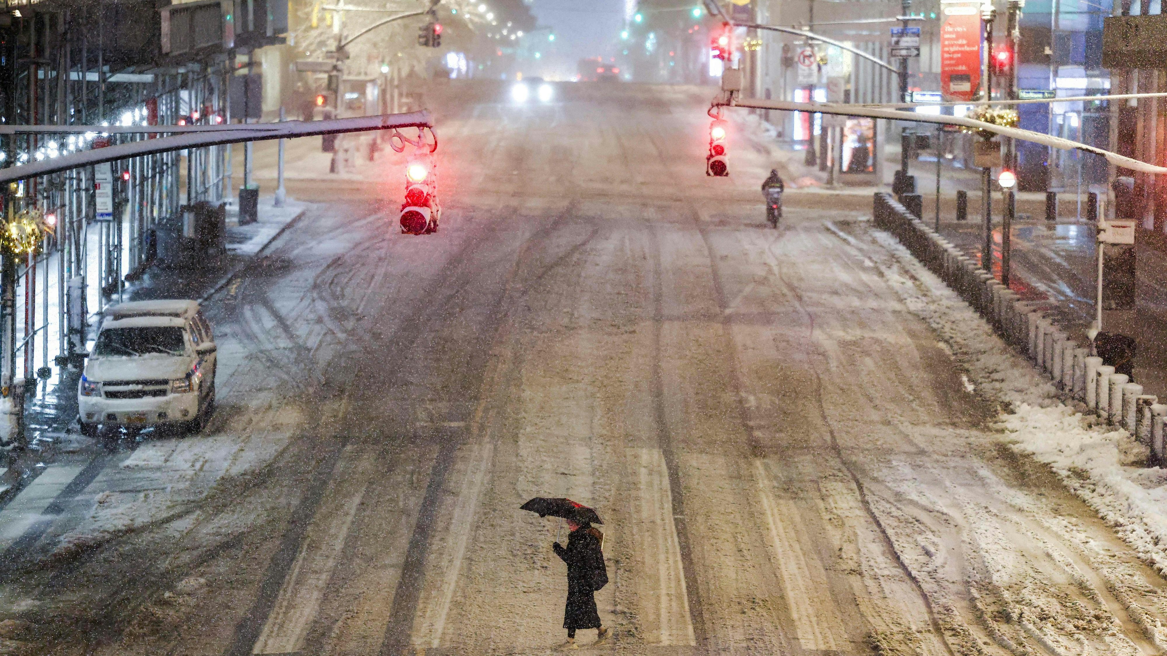 Eine Frau überquert eine fast menschenleere Straße in Manhattan.