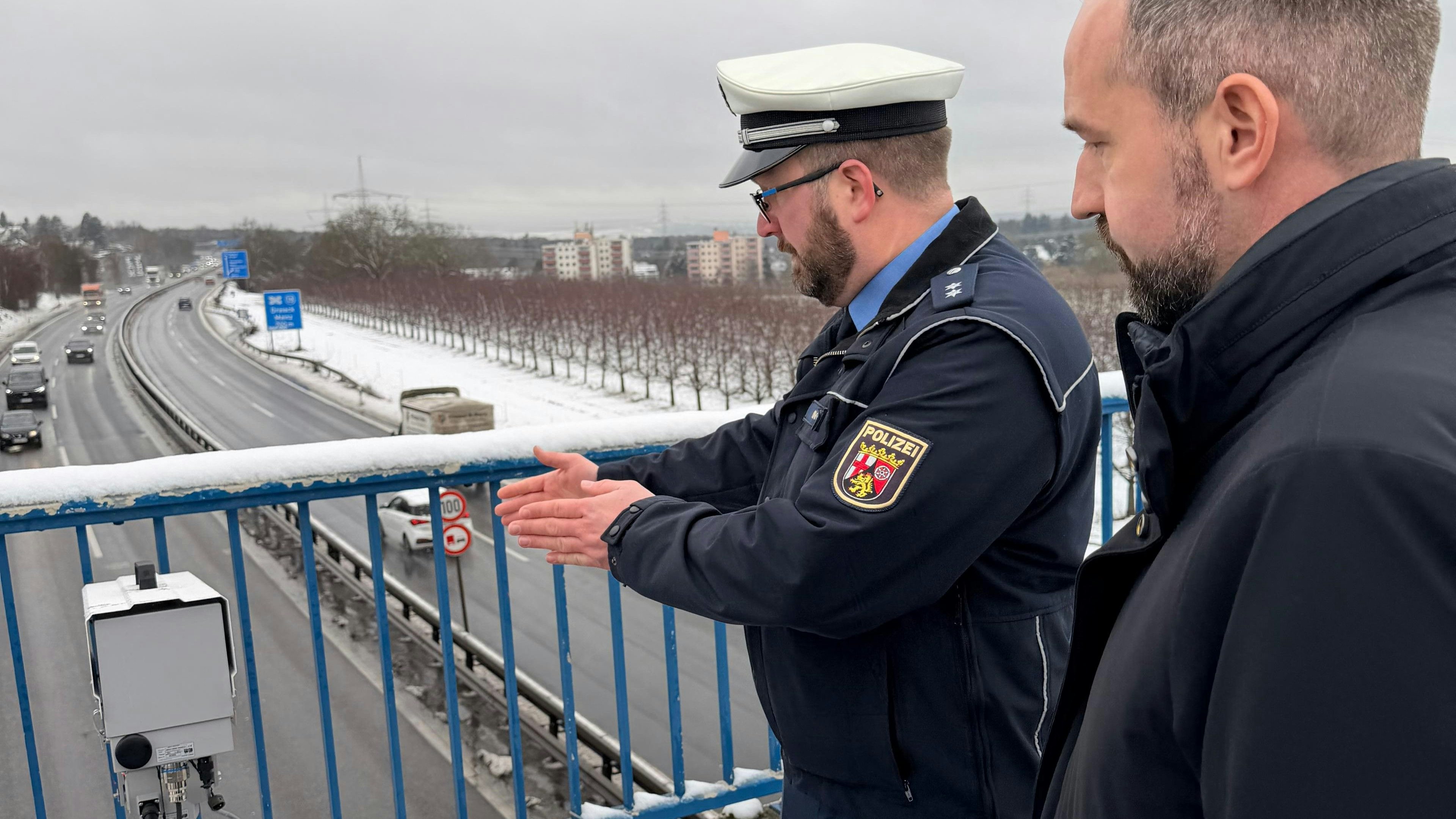 Ein Rheinland-pfälzischer Hauptkommissar erklärt Salzburgs Verkehrslandesrat Stefan Schnöll die Funktionsweise des Handyblitzers.