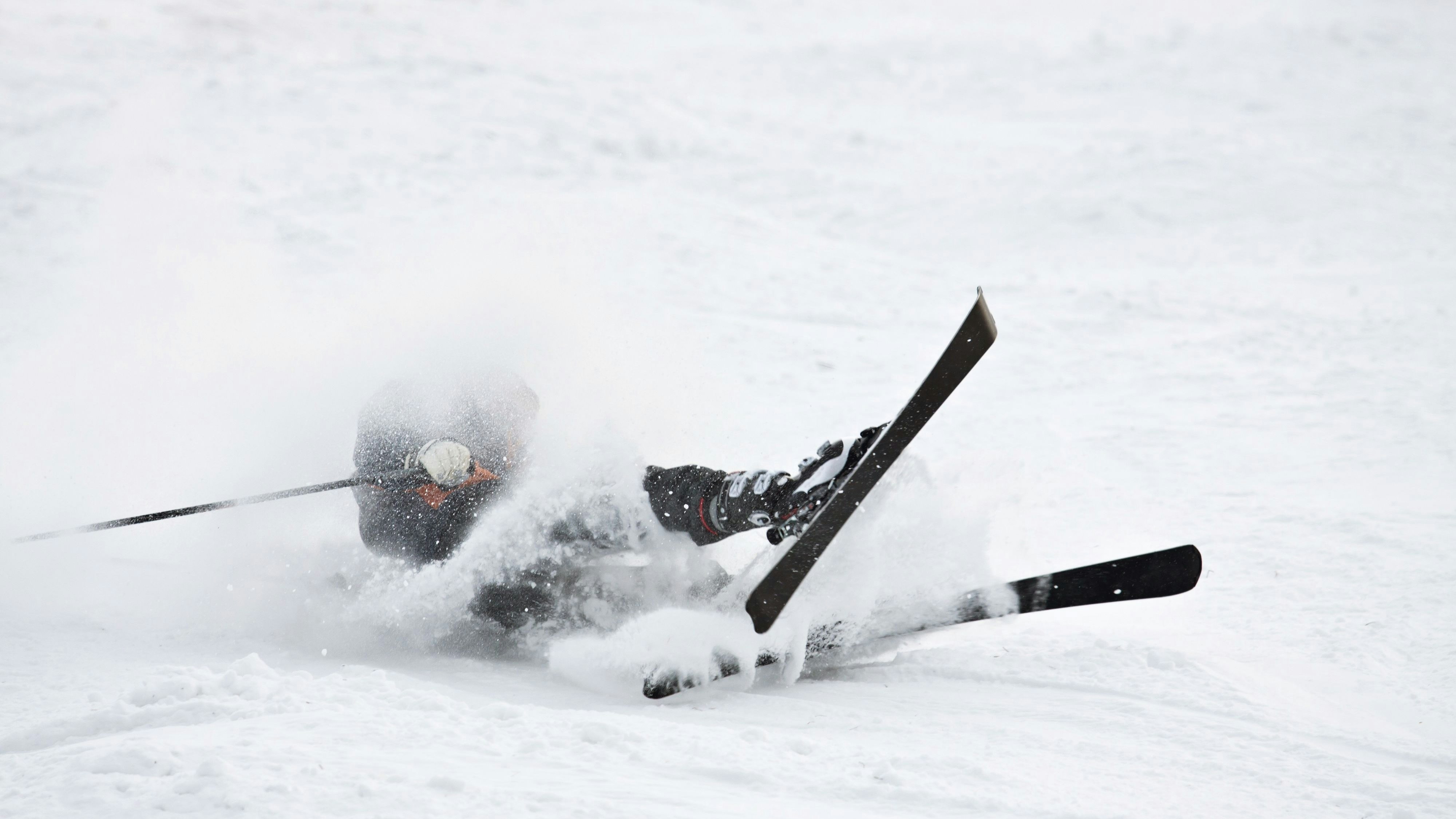 Man riding on skis fall down, he could break something.
