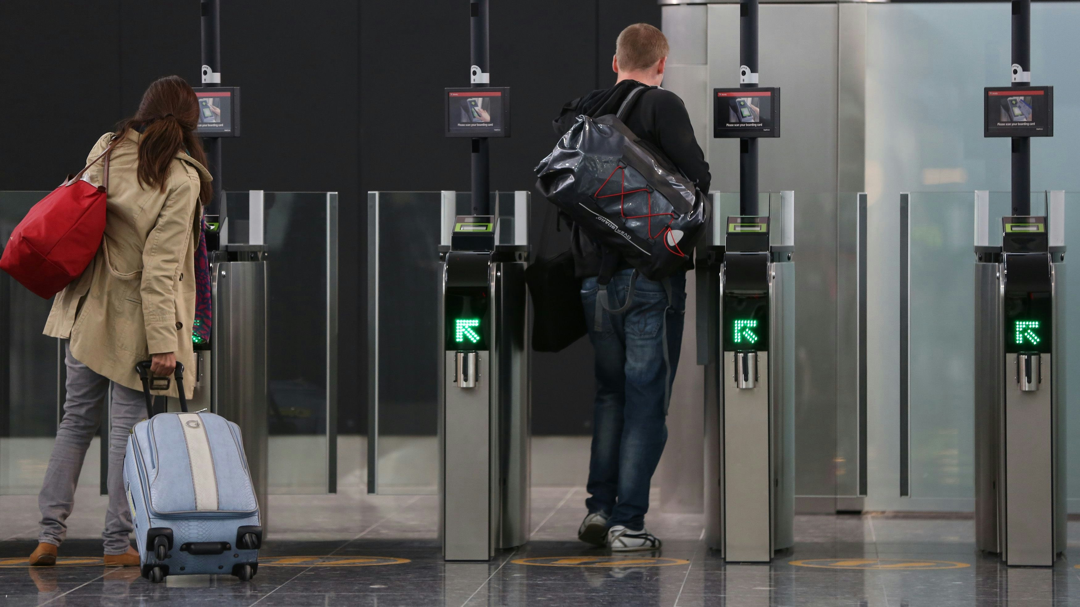 Passengers scan their boarding passes in Terminal 2 at Heathrow Airport in London June 4, 2014. Heathrow's rebuilt Terminal 2 welcomed its first passengers on Wednesday, as it began its gradual re-opening.   REUTERS/Neil Hall (BRITAIN - Tags: TRANSPORT BUSINESS TRAVEL)