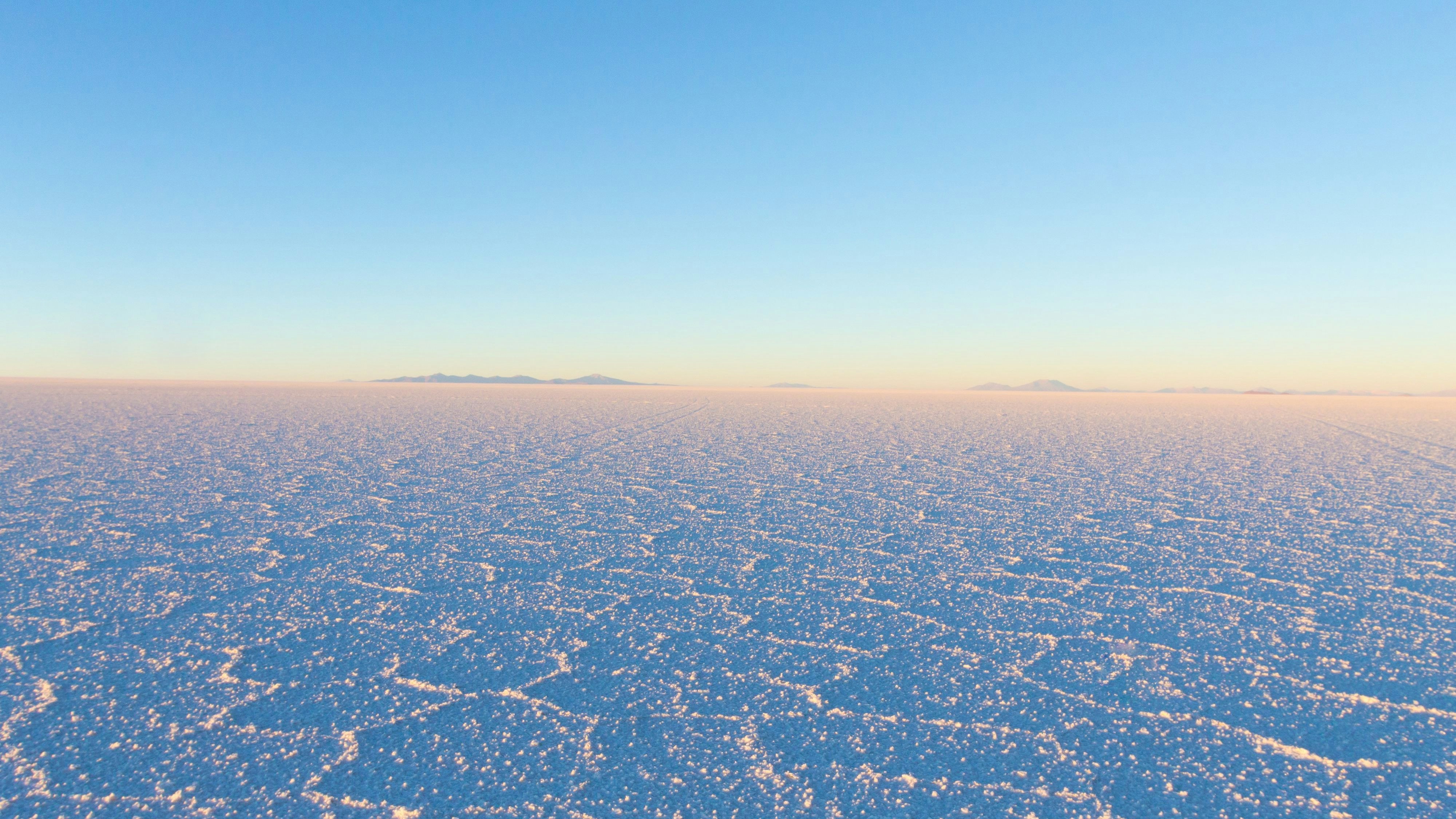 Der <strong>Salar de Uyuni</strong> ist die größte Salzpfanne der Welt. Das schneeweiße Salz sorgt für eine unwirkliche Kulisse.