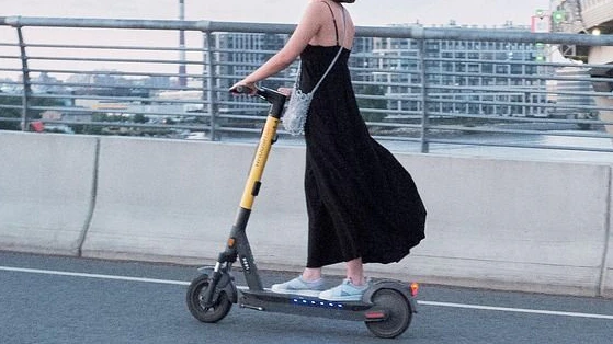Frau auf E-Scooter im Straßenverkehr