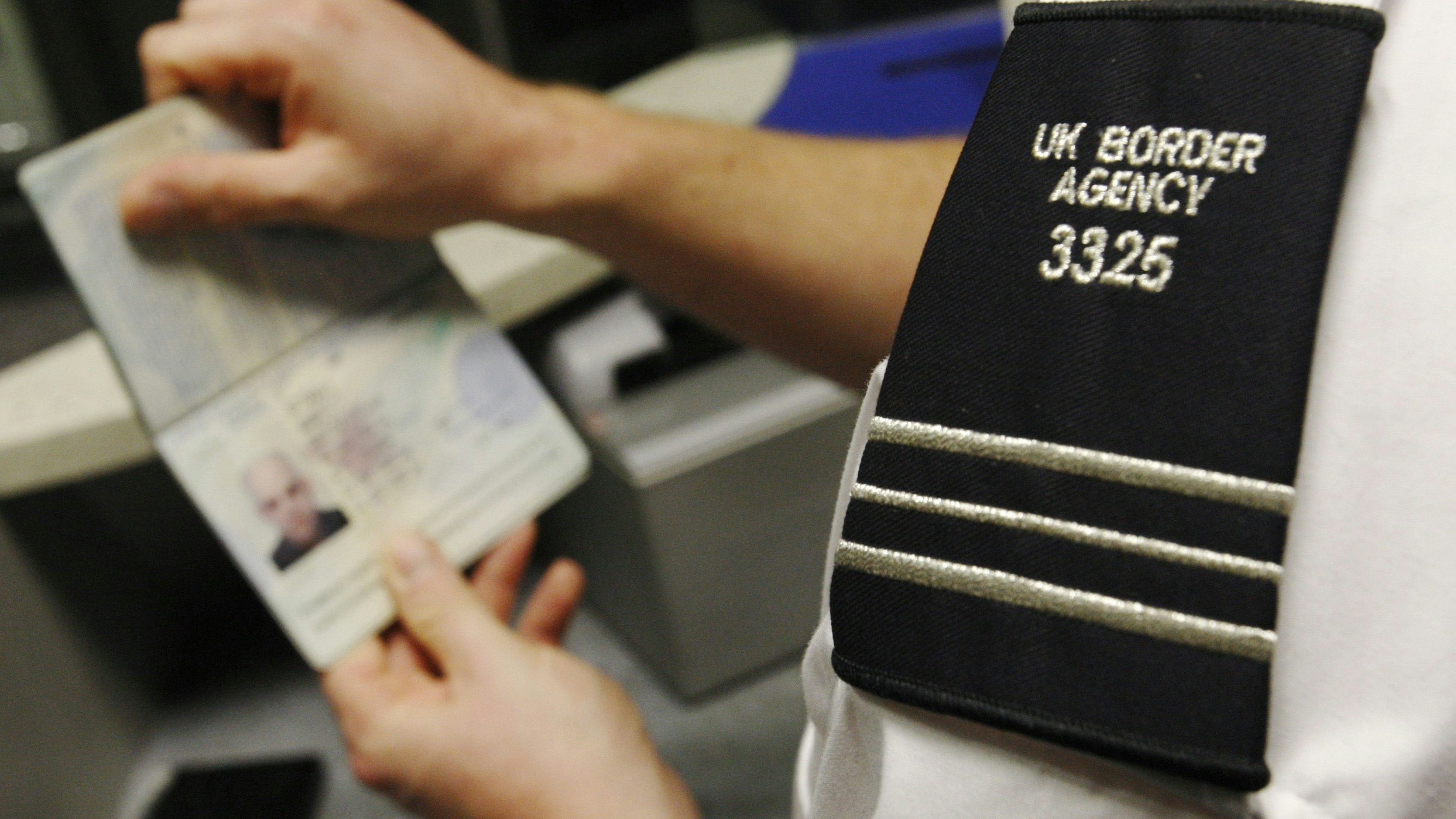 A UK Border Agency worker poses with a passport during a demonstration of the new facial recognition gates at the North Terminal of Gatwick Airport near London, November 23, 2009. The gates can be used by any British or EEA national who holds a biometric passport and are designed to speed travellers through immigration control.   REUTERS/Luke MacGregor   (BRITAIN TRANSPORT TRAVEL)
