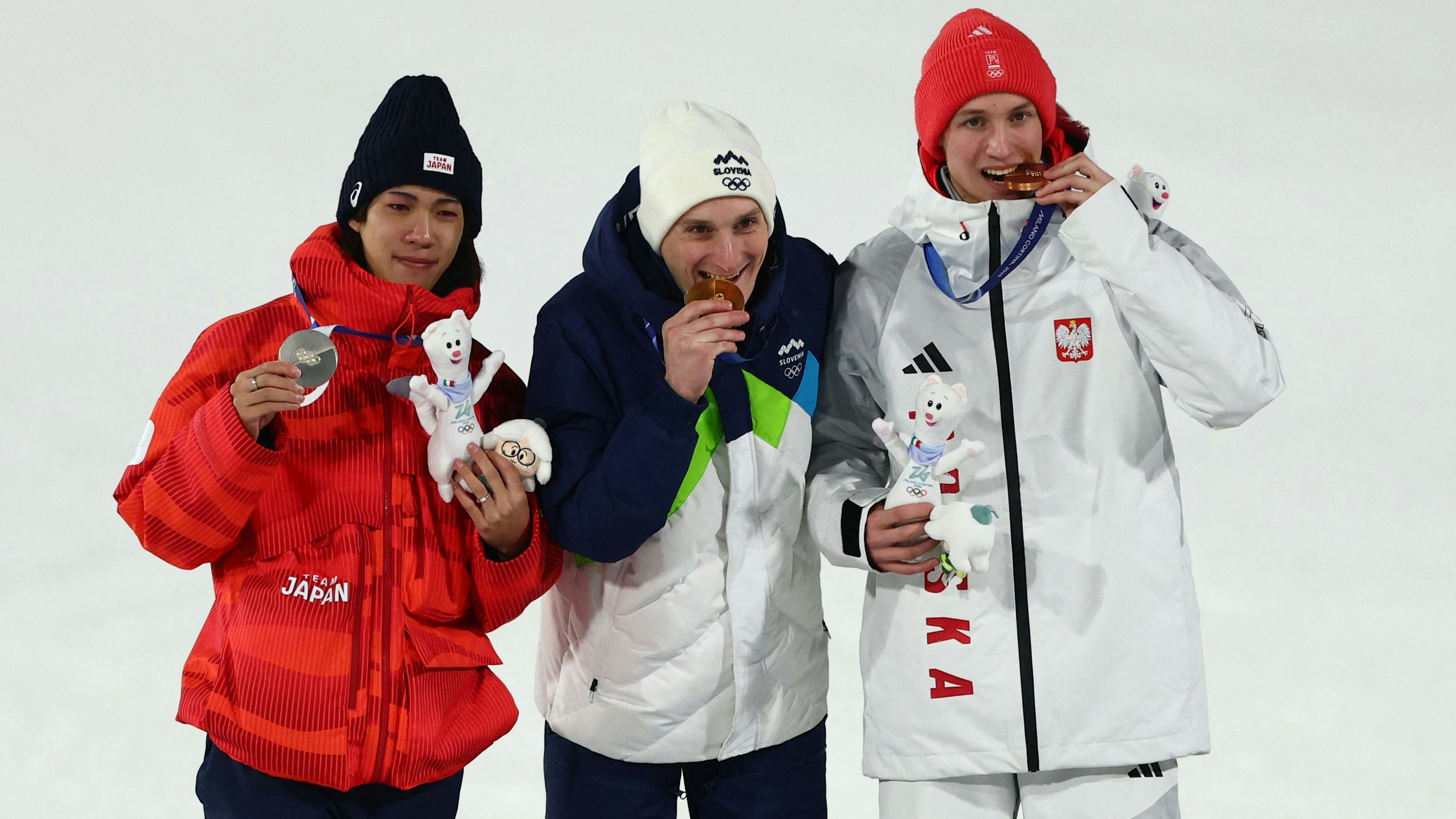 Ren Nikaido, Domen Prevc und Kacper Tomasiak jubelten auf der Großschanze von Predazzo über ihre Olympia-Medaillen.