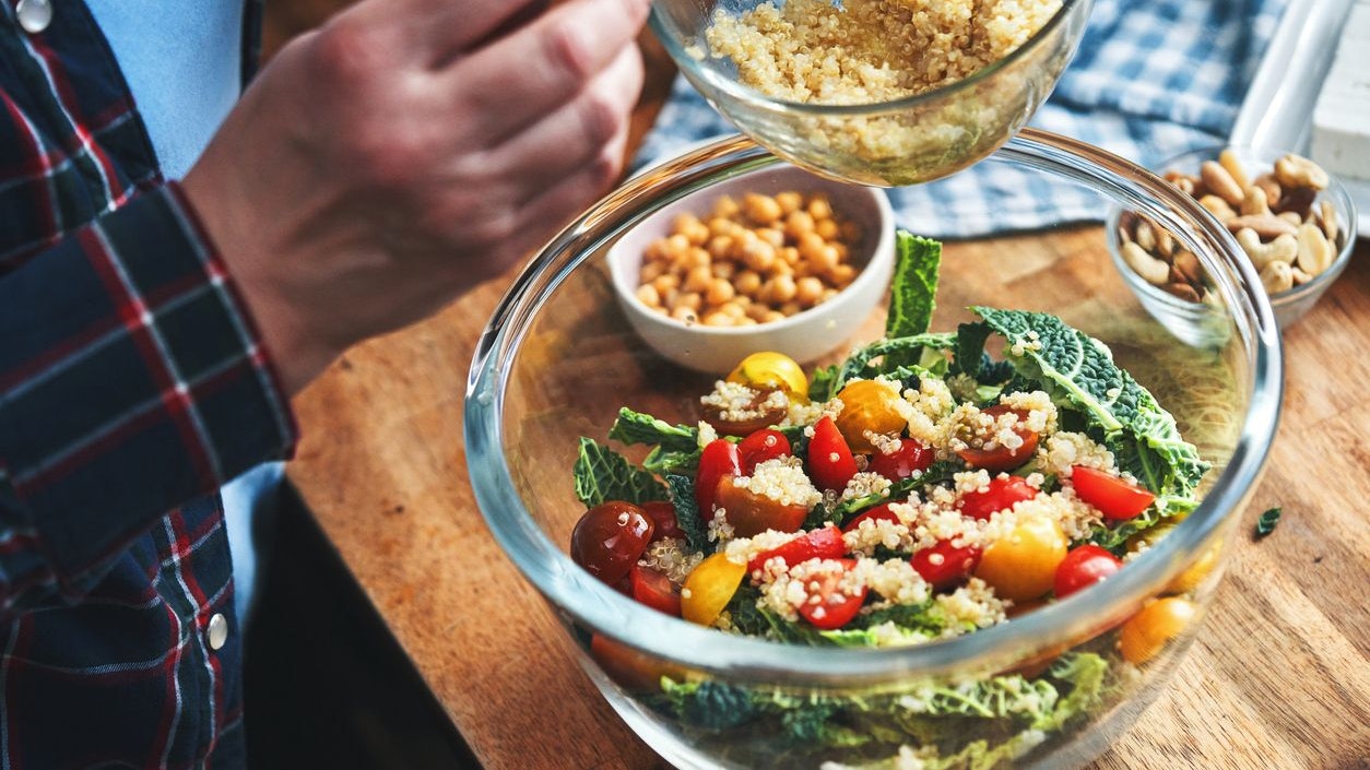 Preparing Kale, Quinoa Salad with Tofu, Tomatoes, Nuts and Chickpeas for a Healthy Meal