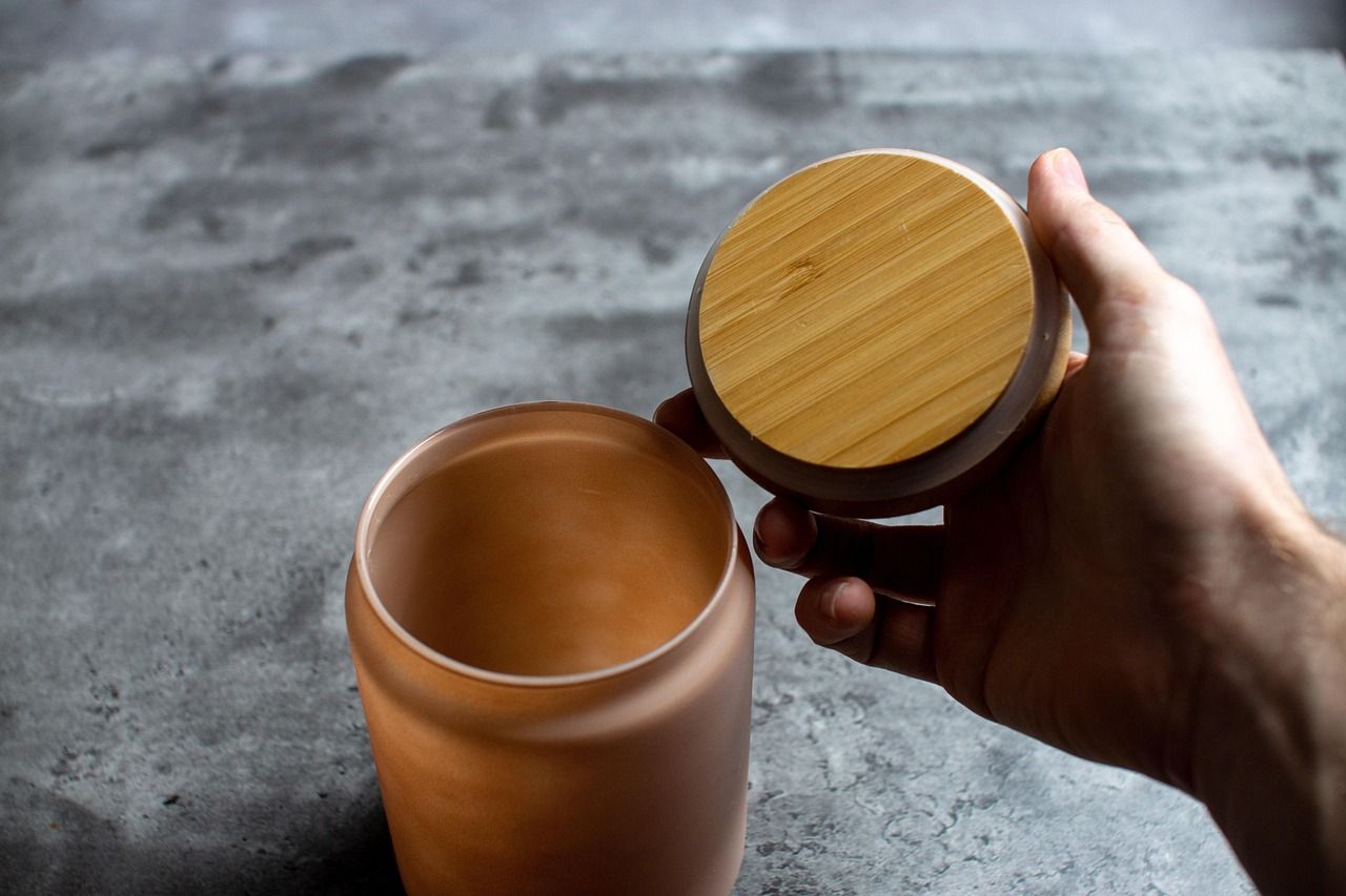 Hand öffnet Behälter mit Deckel