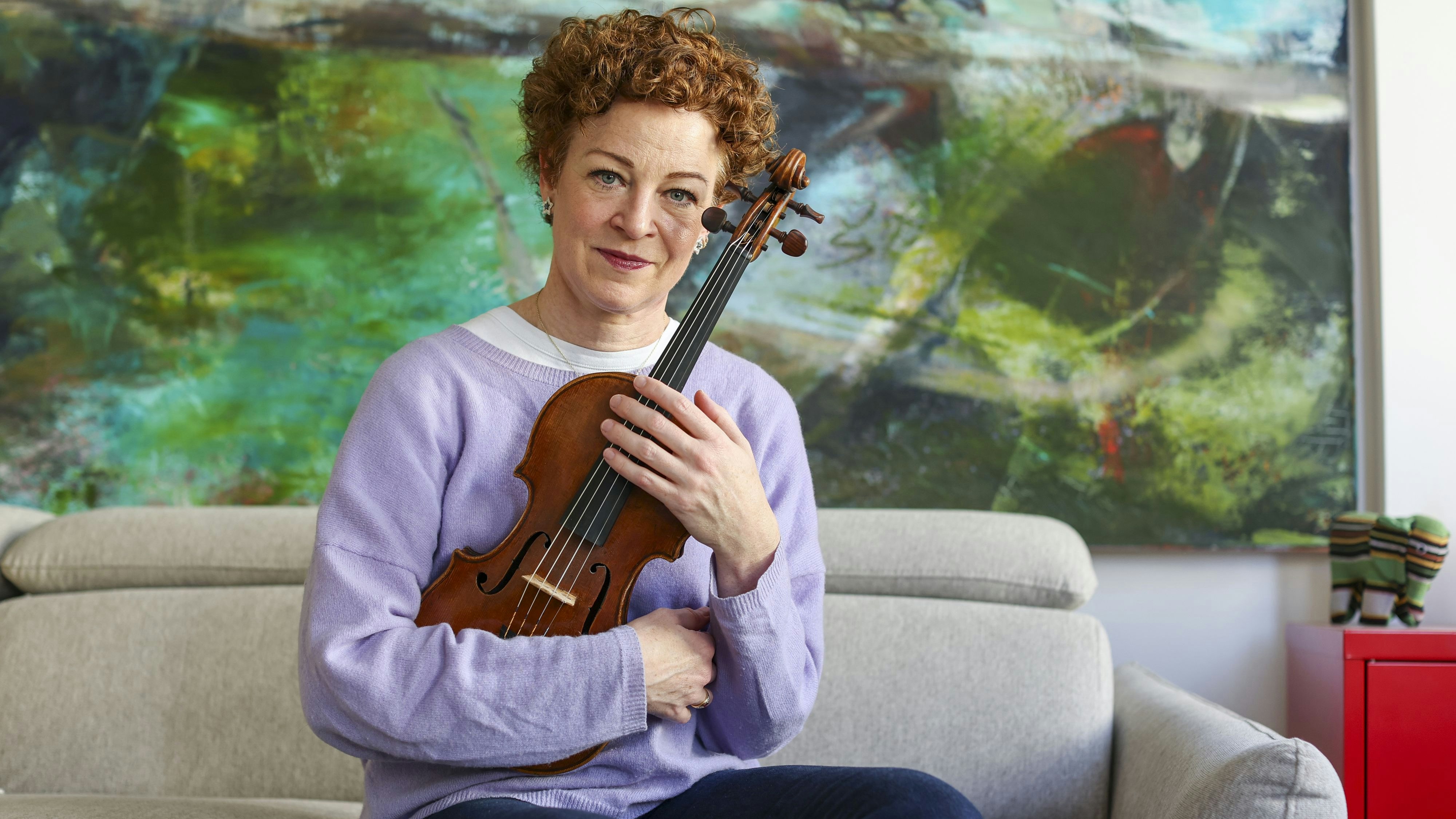 03 March 2026, Saxony, Leipzig: Carolin Widmann sits in her apartment with her 244-year-old violin. The musician was not allowed to take her violin case on board a flight. She then unpacked the valuable instrument made by Giovanni Battista Guadagnini in 1782 and held it on her lap like a baby during the flight. She then wrote an open letter to the CEO of Lufthansa. The latter relents and introduces an exception to the strict hand luggage rules. Photo: Jan Woitas/dpa