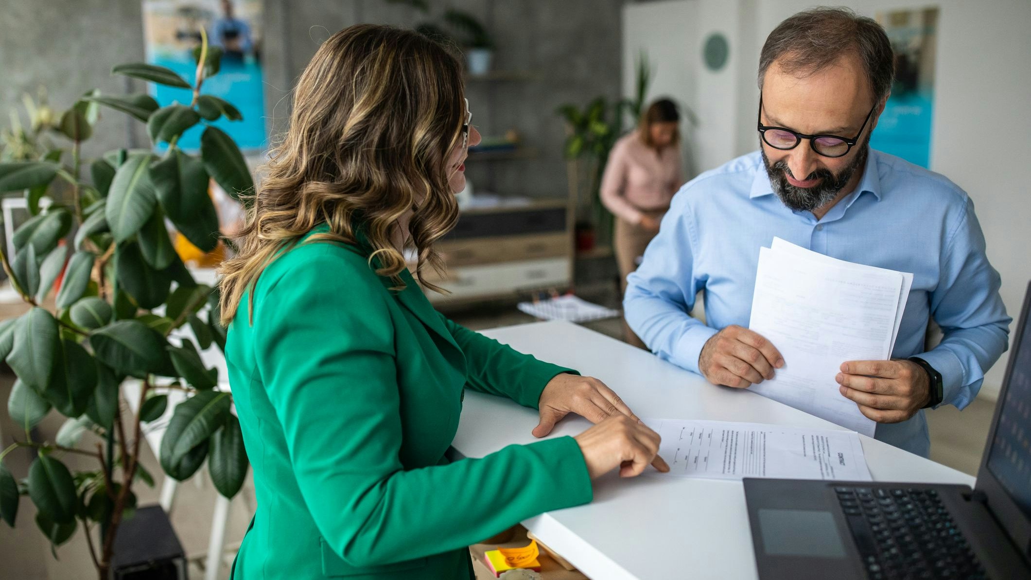 Businessman standing at bank counter and talking with financial advisor
