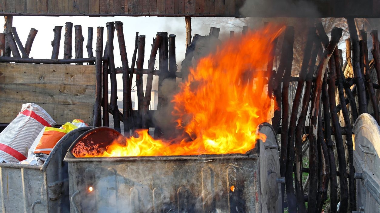 Dumpster fire with heavy smoke from garbage