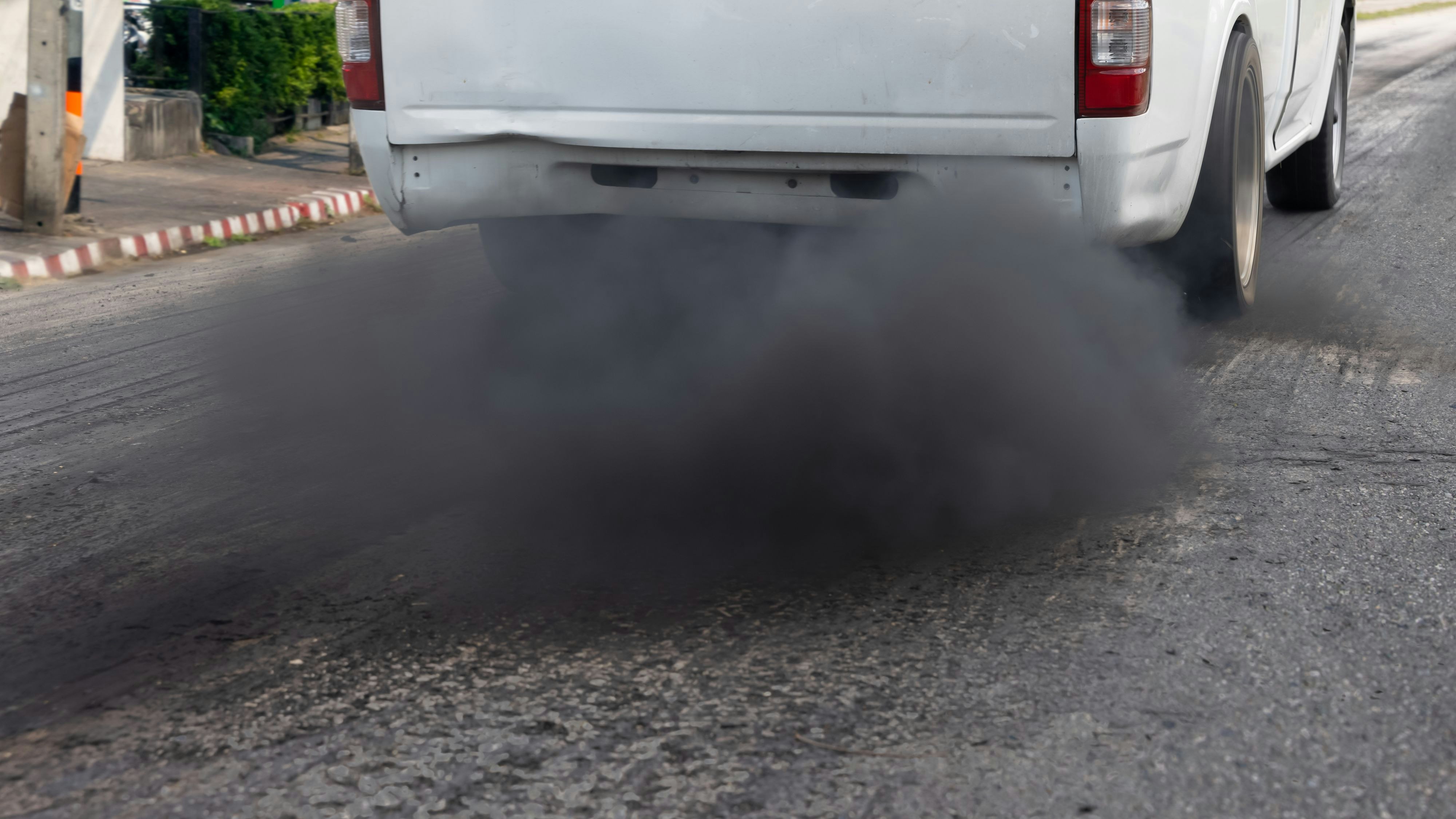 Climate change and air pollution crisis in city from diesel vehicle exhaust pipe on road