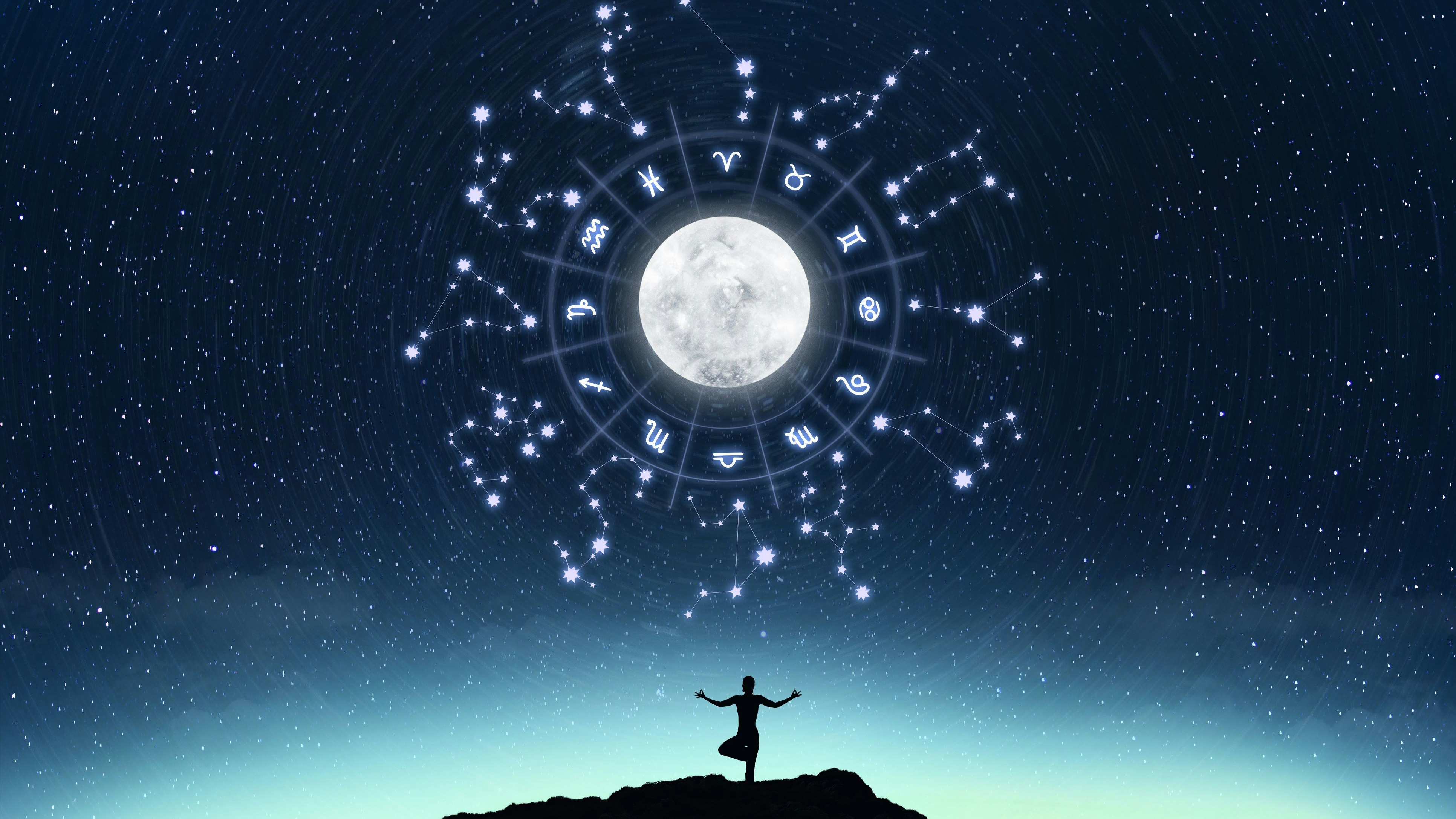 A silhouette of a person gazing at the moon with glowing zodiac symbols and constellations in the night sky.
