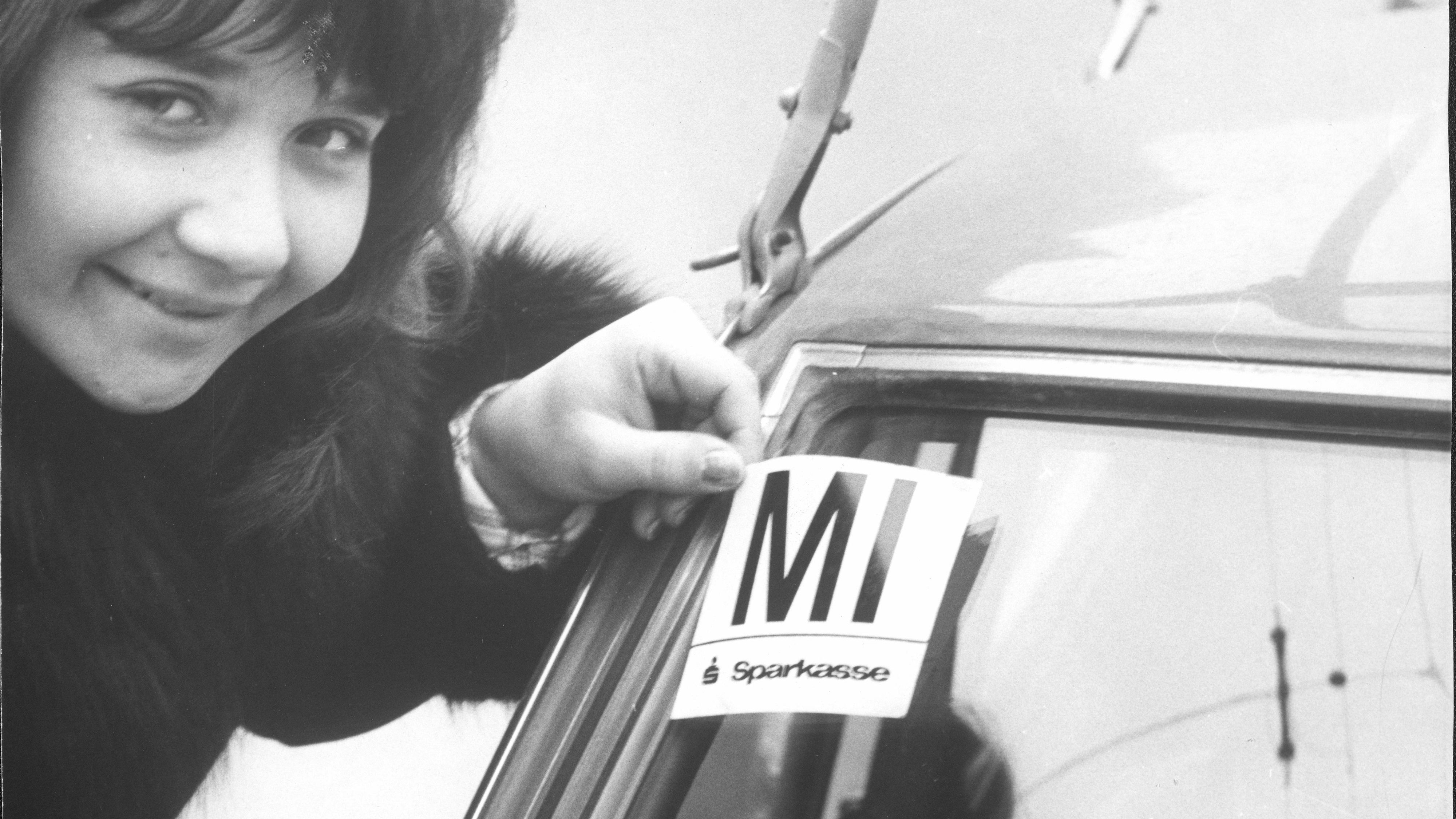 Autofreier Tag, eine Frau klebt ein Mittwoch-Pickerl auf die Windschutzscheibe