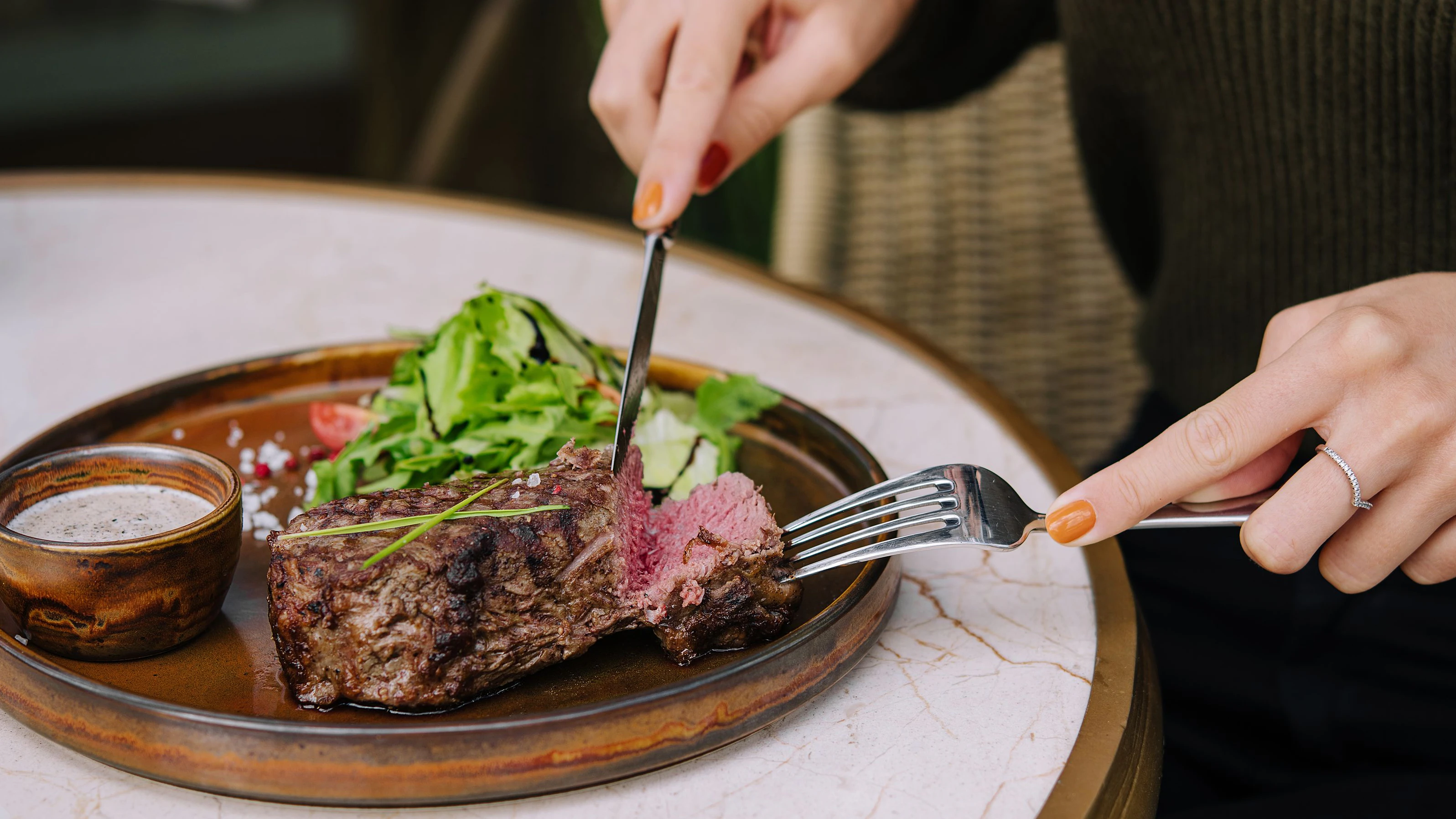Frau schneidet ihr Steak an...