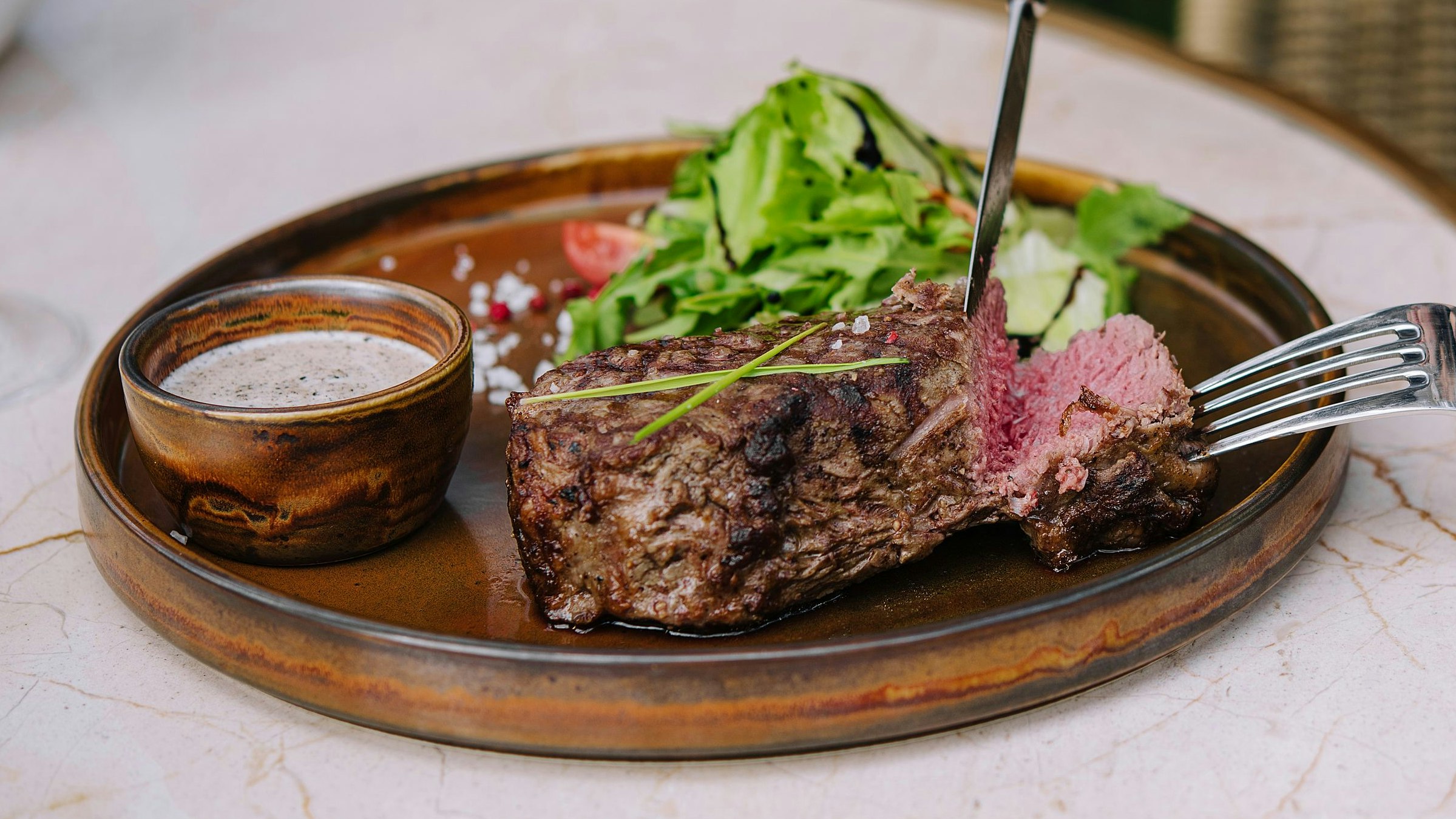 Frau schneidet ihr Steak an...