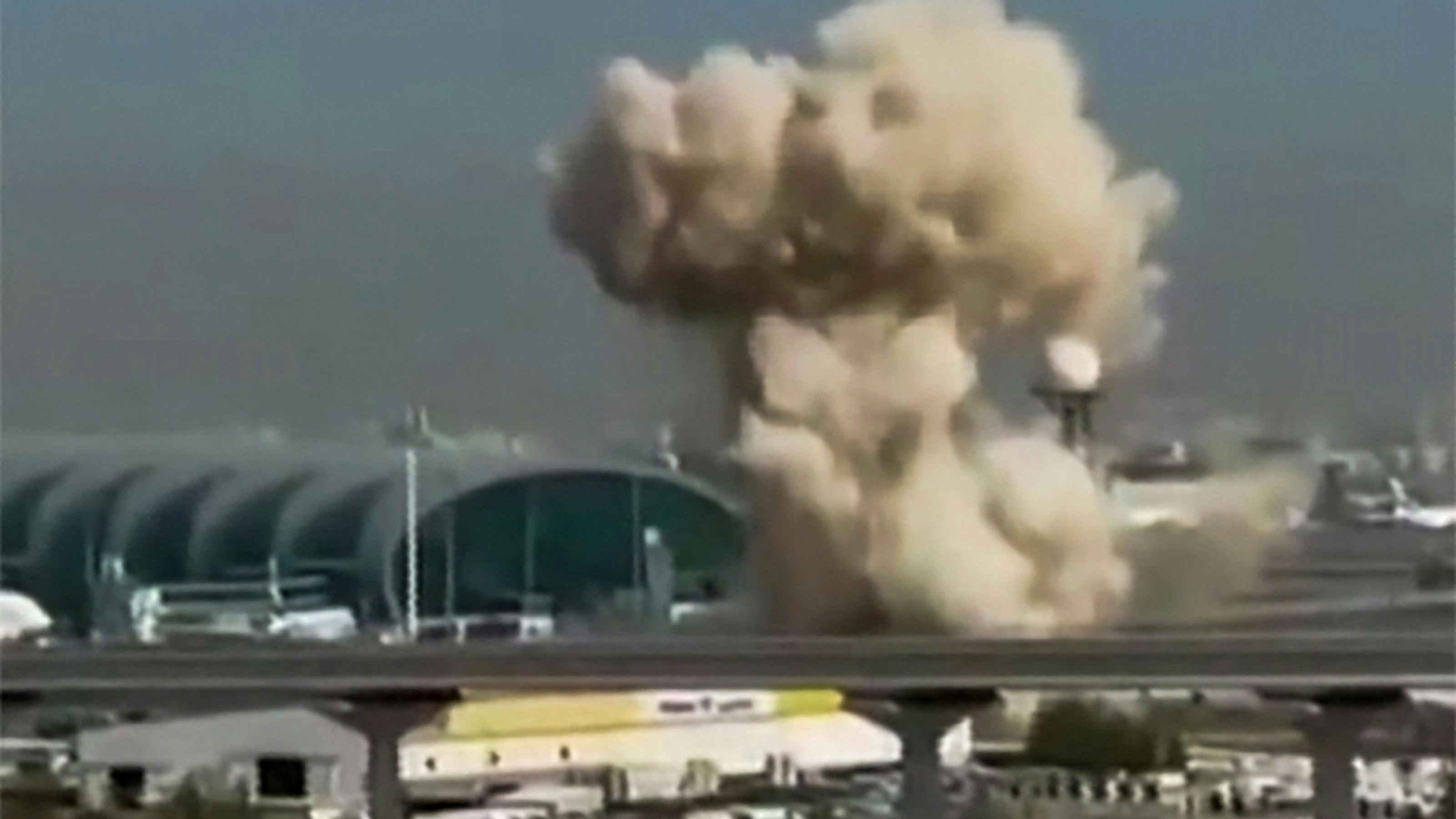 *** HANDOUT *** TOPSHOT - This video grab taken from UGC images posted on social media on March 7, 2026 shows smoke rising from the Dubai International Airport. Dubai airport, the world's busiest for international traffic, suspended operations on March 7 before partially resuming services, after an air defence interception in the area during attacks from Iran. (Photo by various sources / AFP) / RESTRICTED TO EDITORIAL USE - MANDATORY CREDIT AFP -  SOURCE: UGC / UNKNOWN - DISTRIBUTED AS A SERVICE TO CLIENTS - NO RESALE -